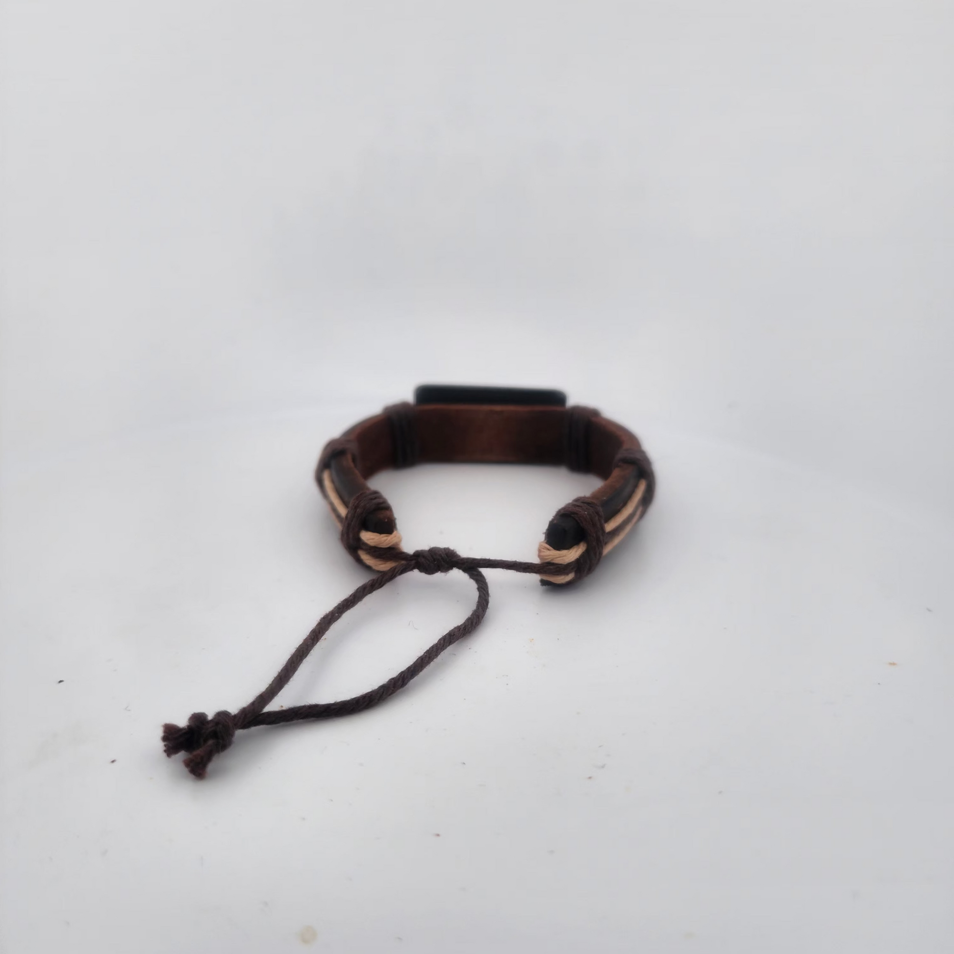 Brown leather bracelet with black accents on a white background