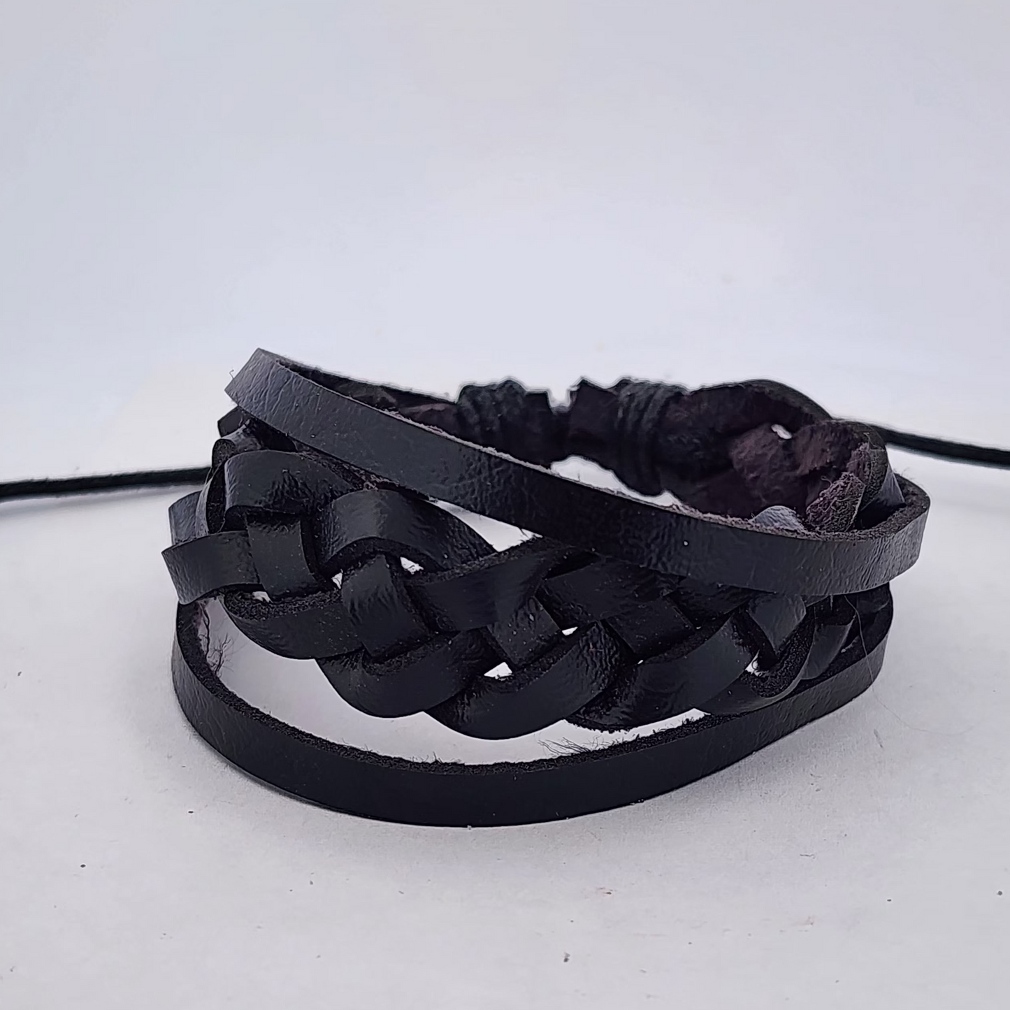 Black braided leather bracelet on a white background