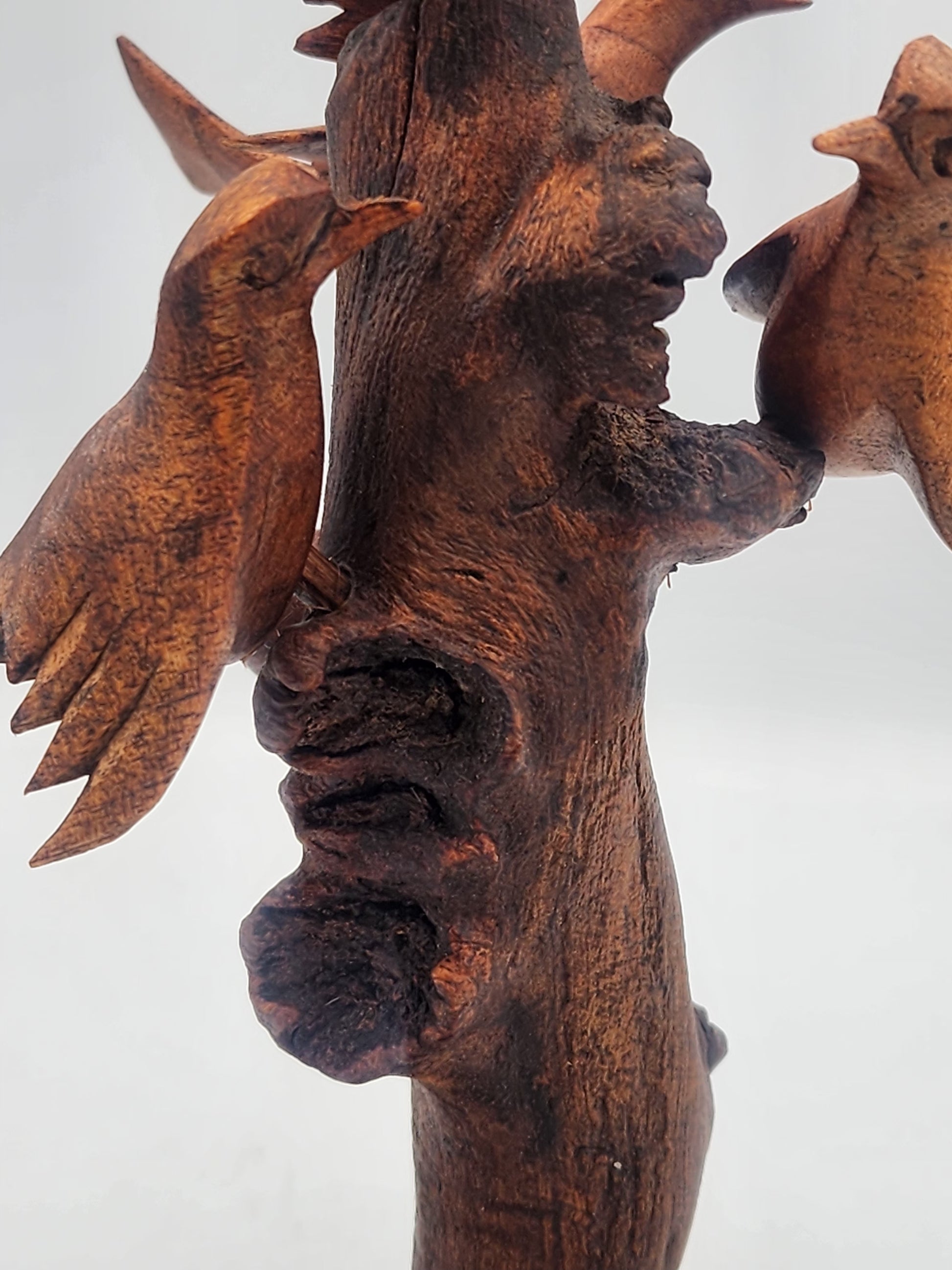 Wooden sculpture of a figure with outstretched arms on a white background