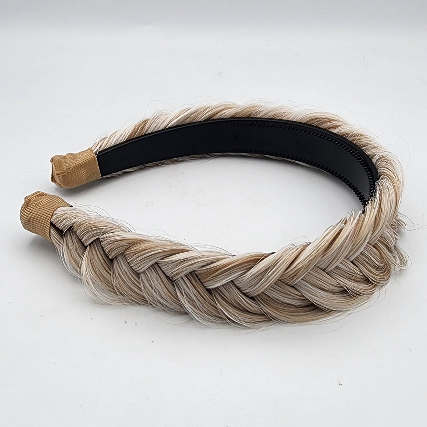 Braided hairband with beige and black sections on a white background