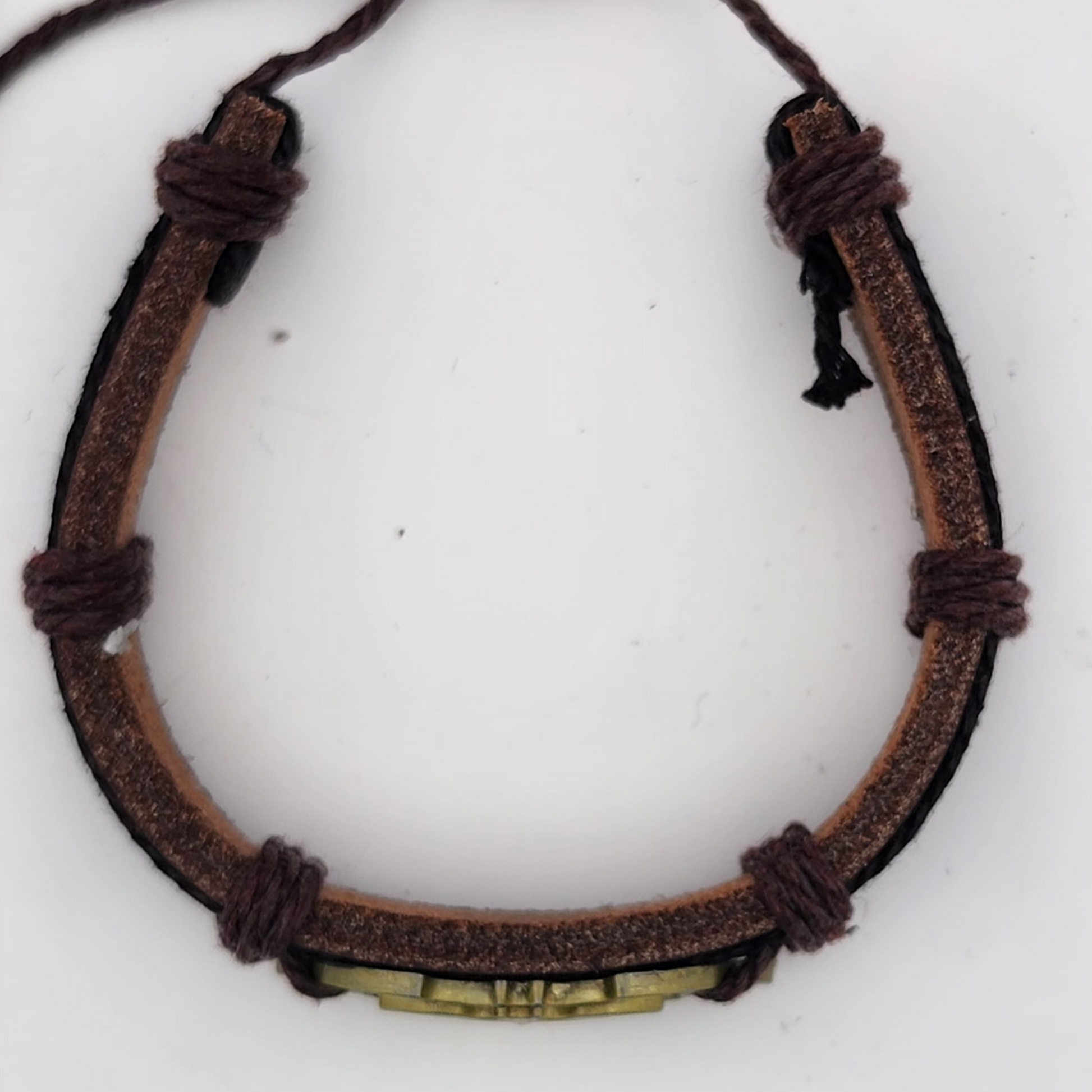 Brown leather bracelet with a metal tag on a white background