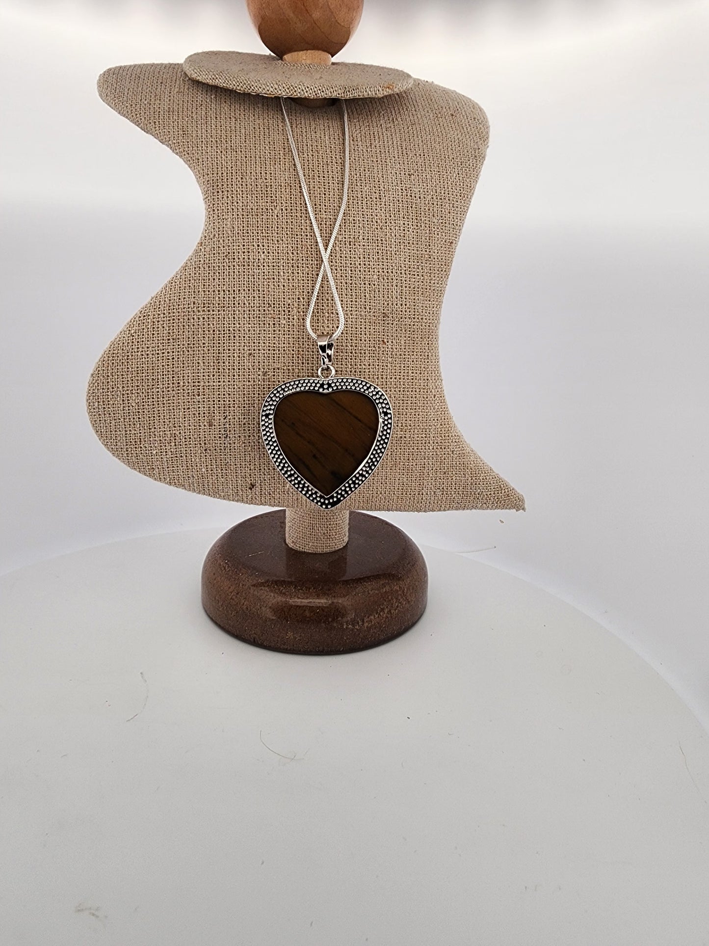 Necklace with a heart-shaped pendant on a mannequin bust against a white background