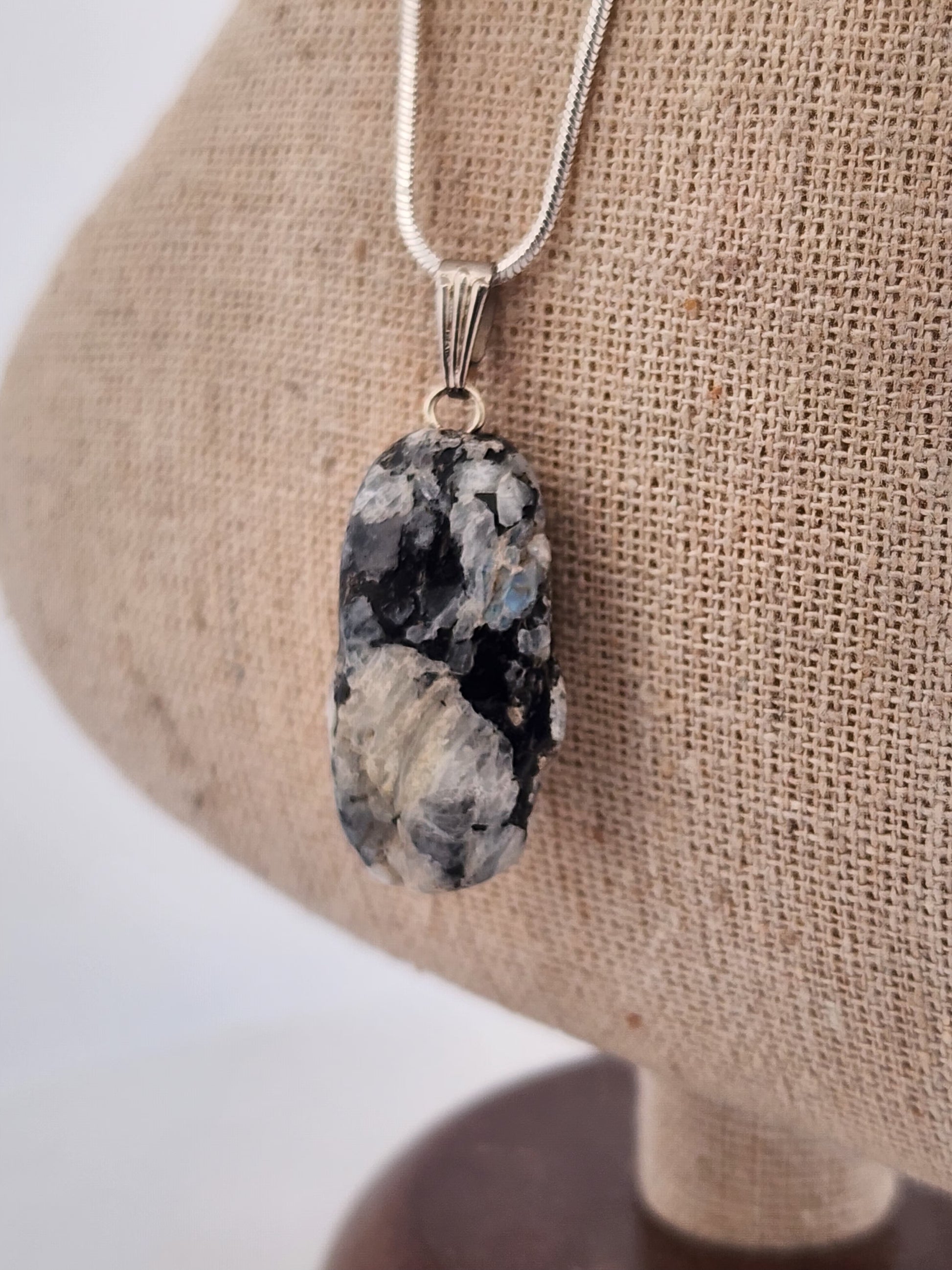 Necklace with a large, rough-textured stone pendant on a neutral background