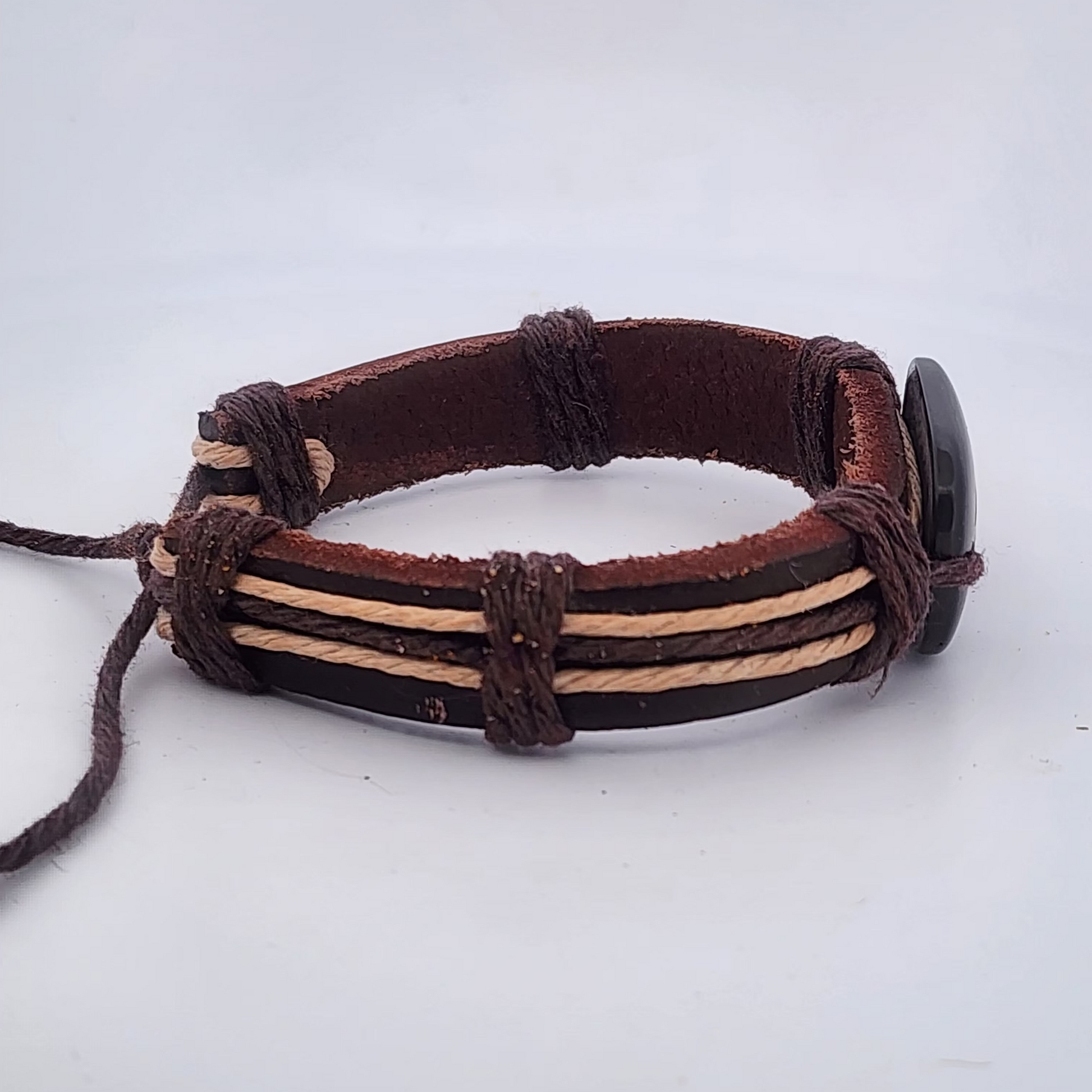 Brown leather bracelet with beige accents on a white background