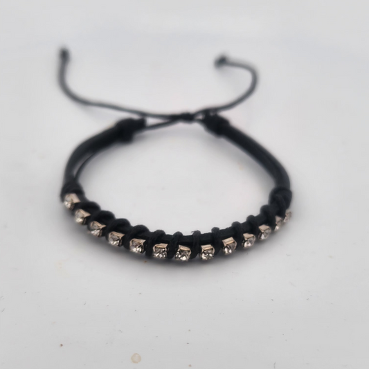 Black bracelet with small beads on a light gray background
