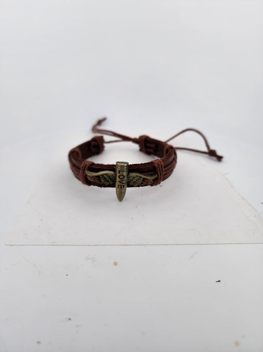 Brown leather bracelet with metal charm on a white surface
