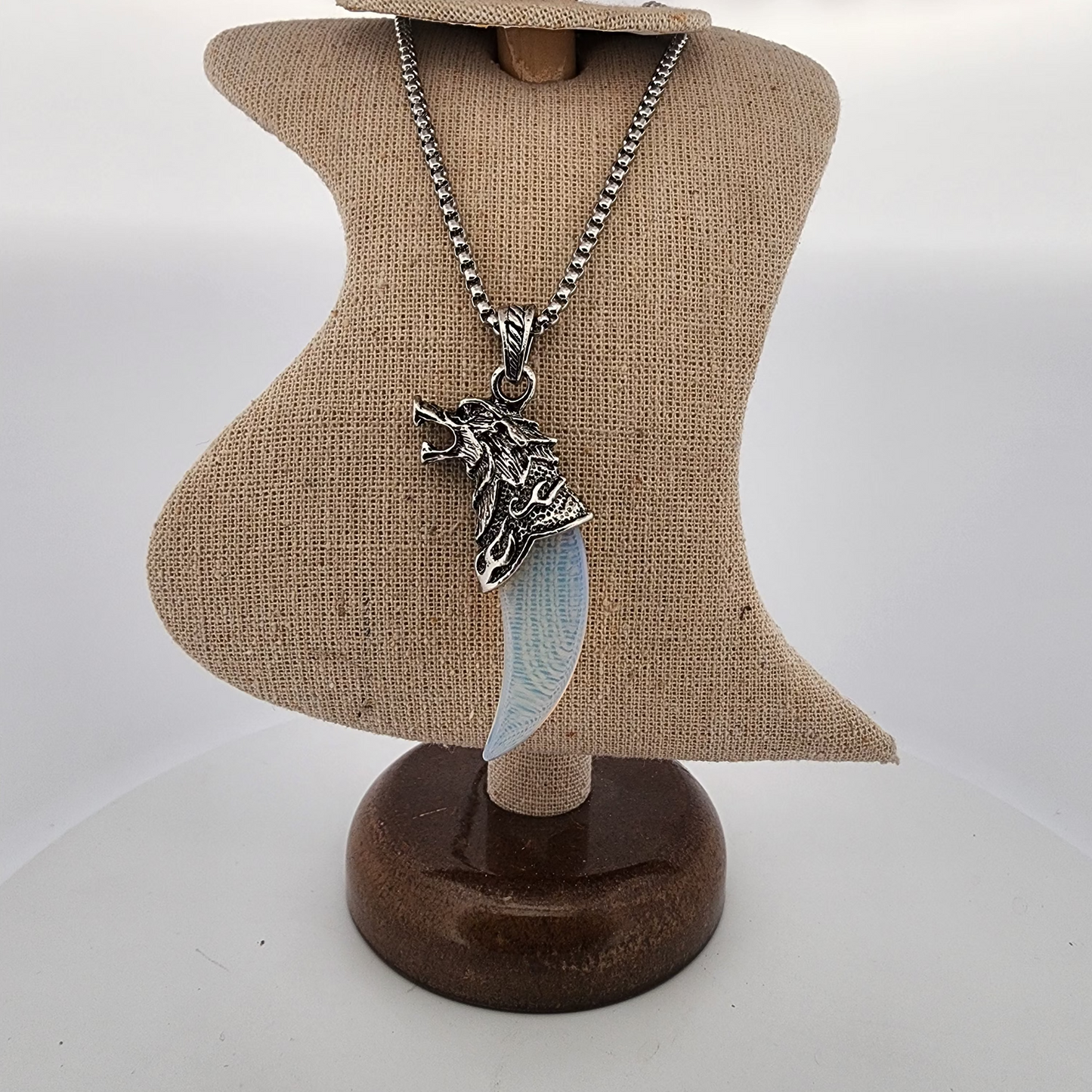 Necklace with a wolf pendant on a mannequin bust against a white background