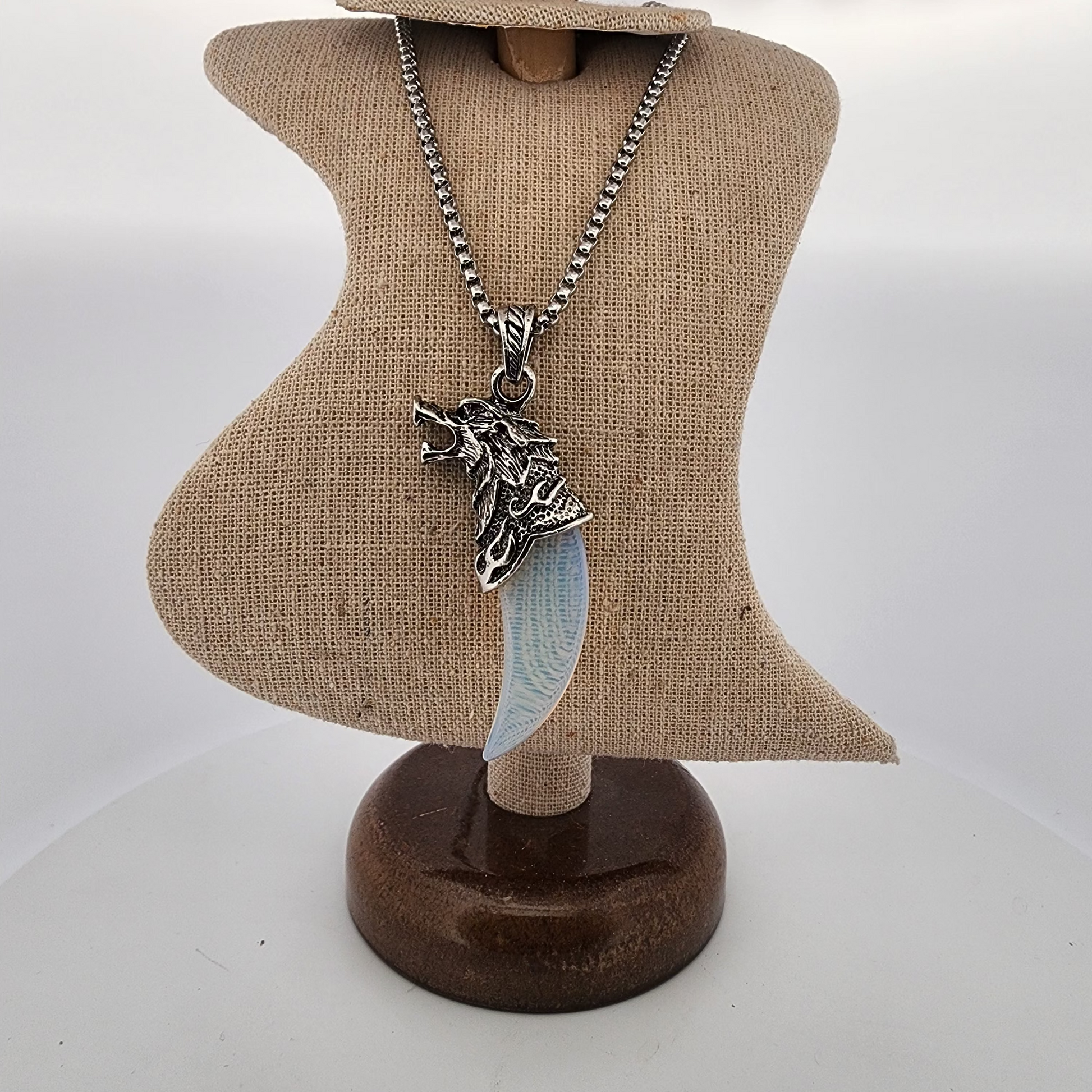 Necklace with a wolf pendant on a mannequin bust against a white background