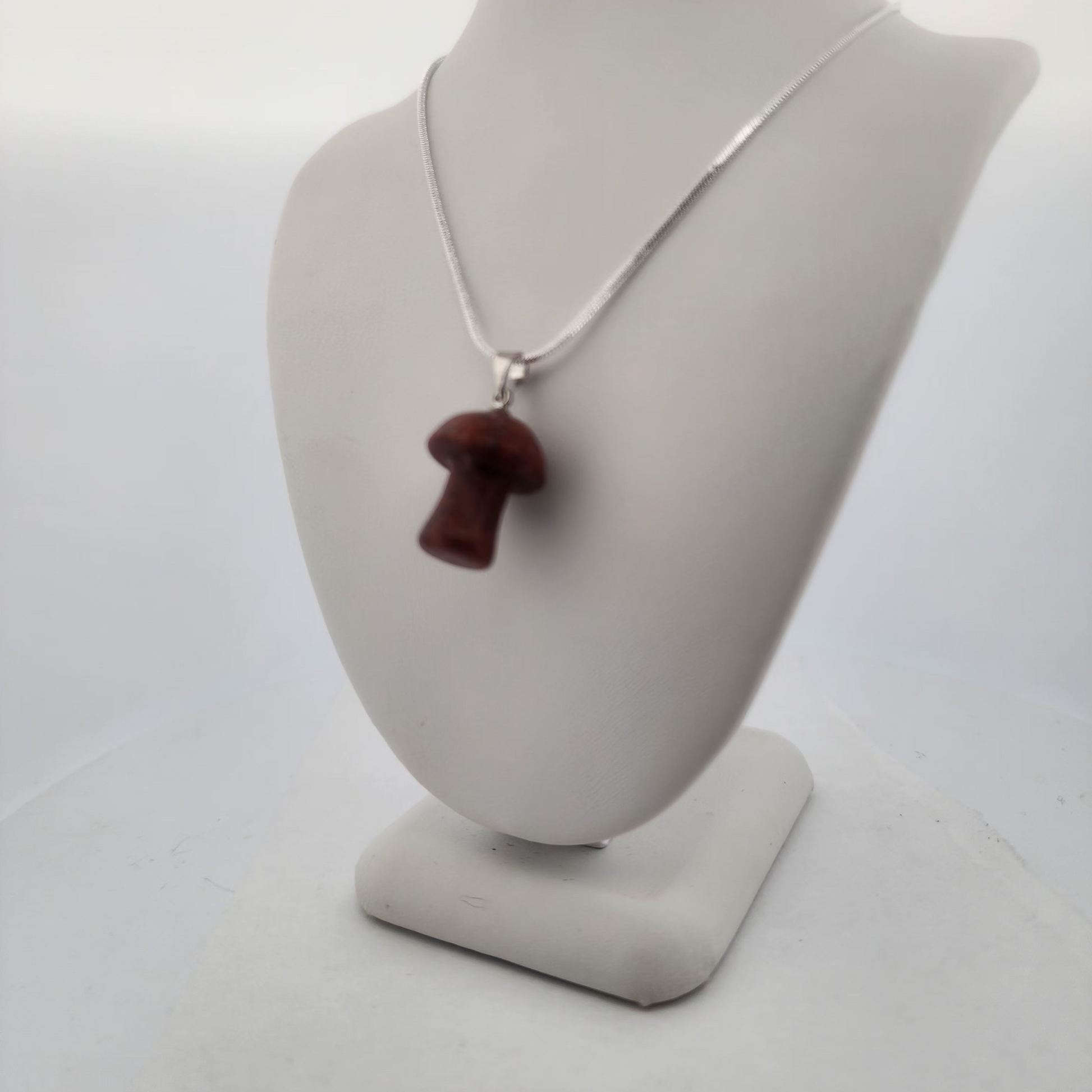 Necklace with a brown pendant on a gray mannequin bust against a white background