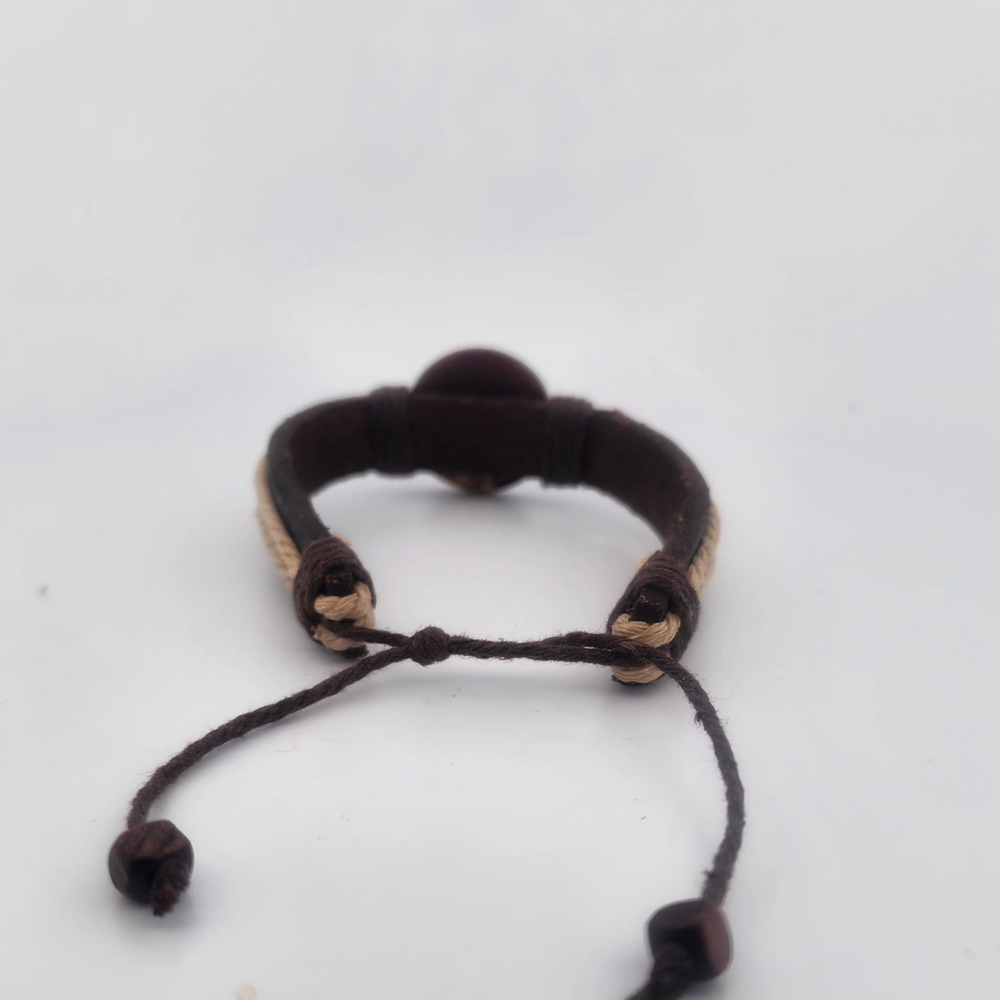 Black cord bracelet with beads on a white background