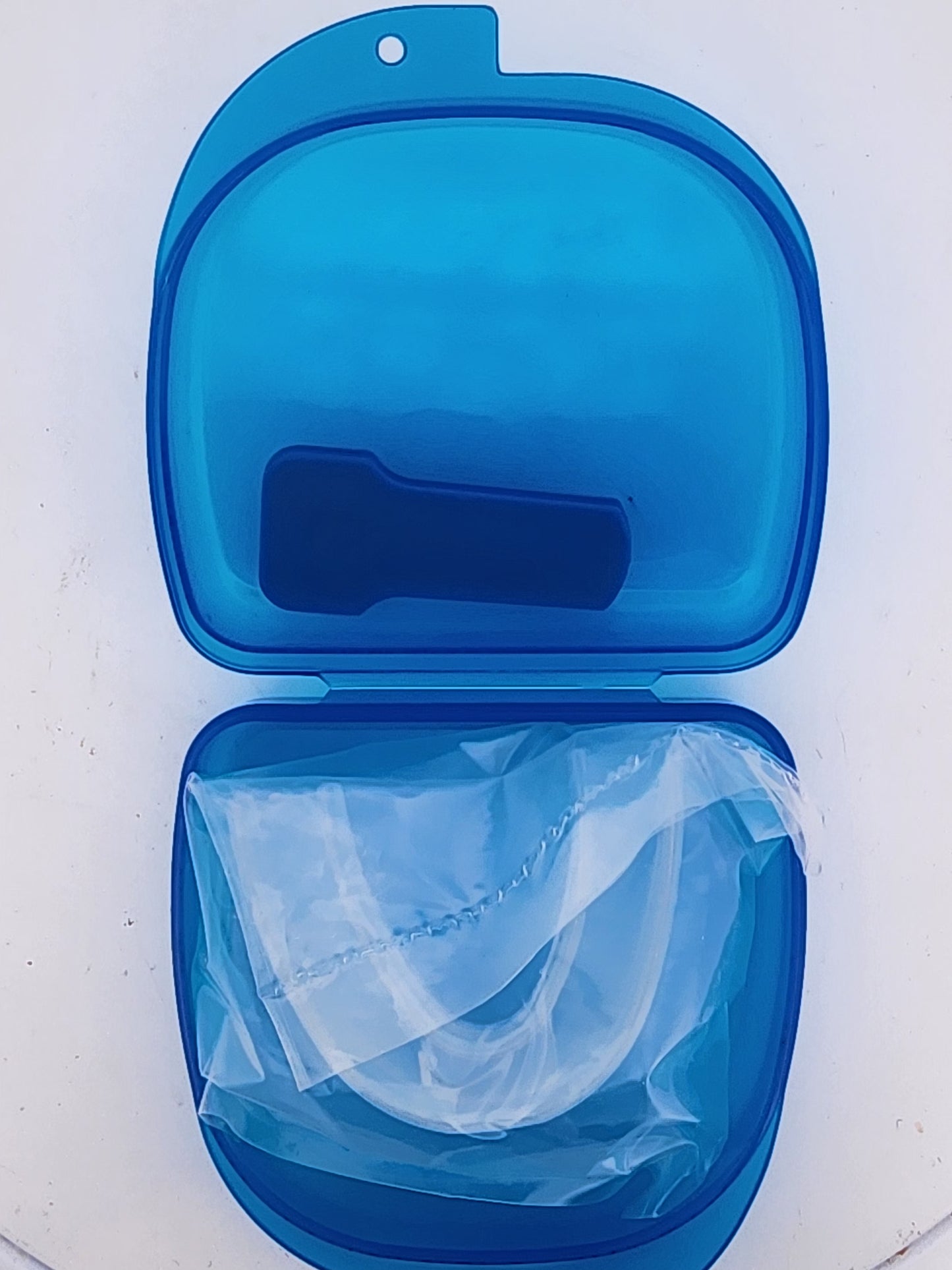 Blue case with a clear mouthguard inside on a white background