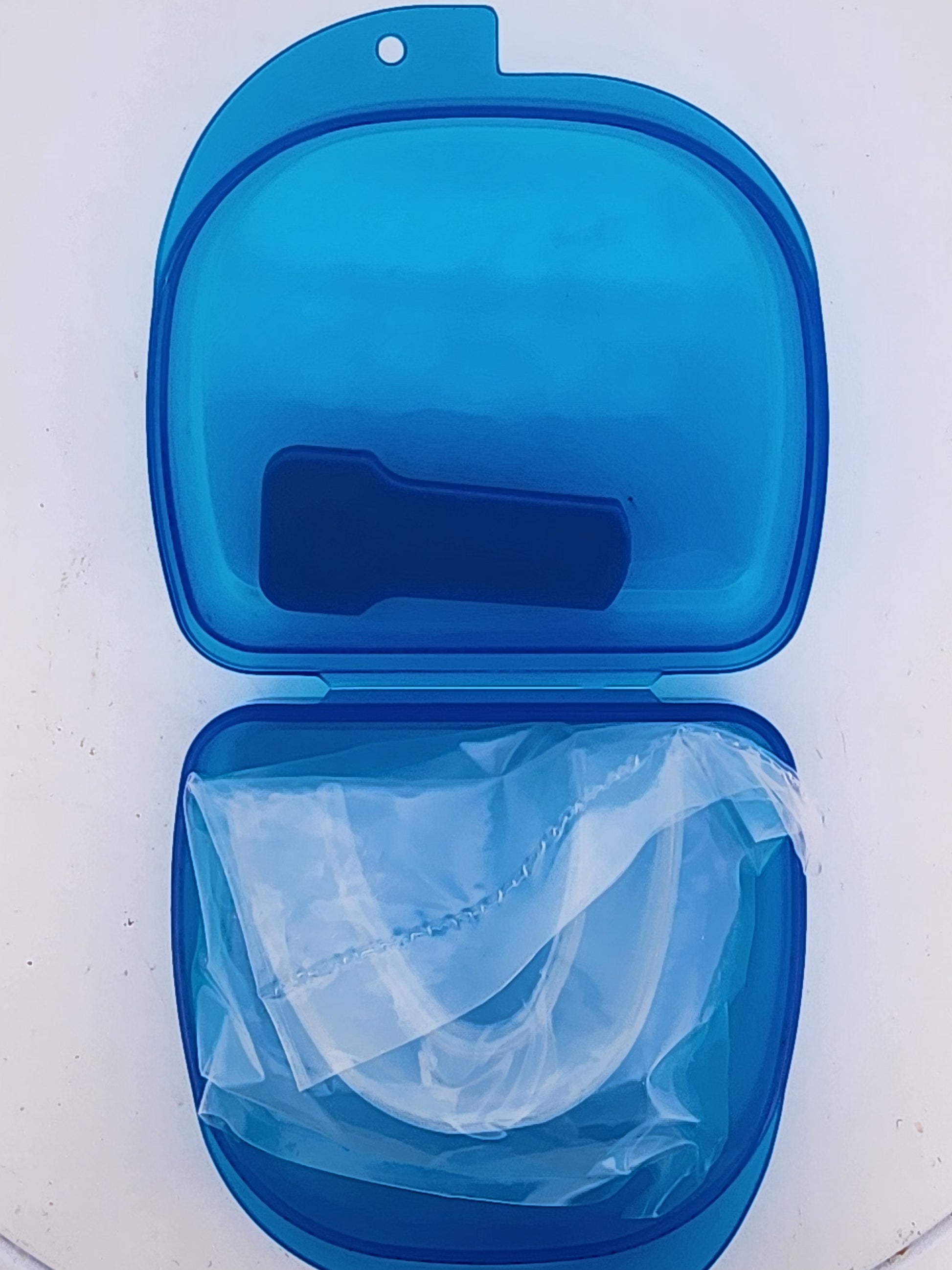 Blue case with a clear mouthguard inside on a white background