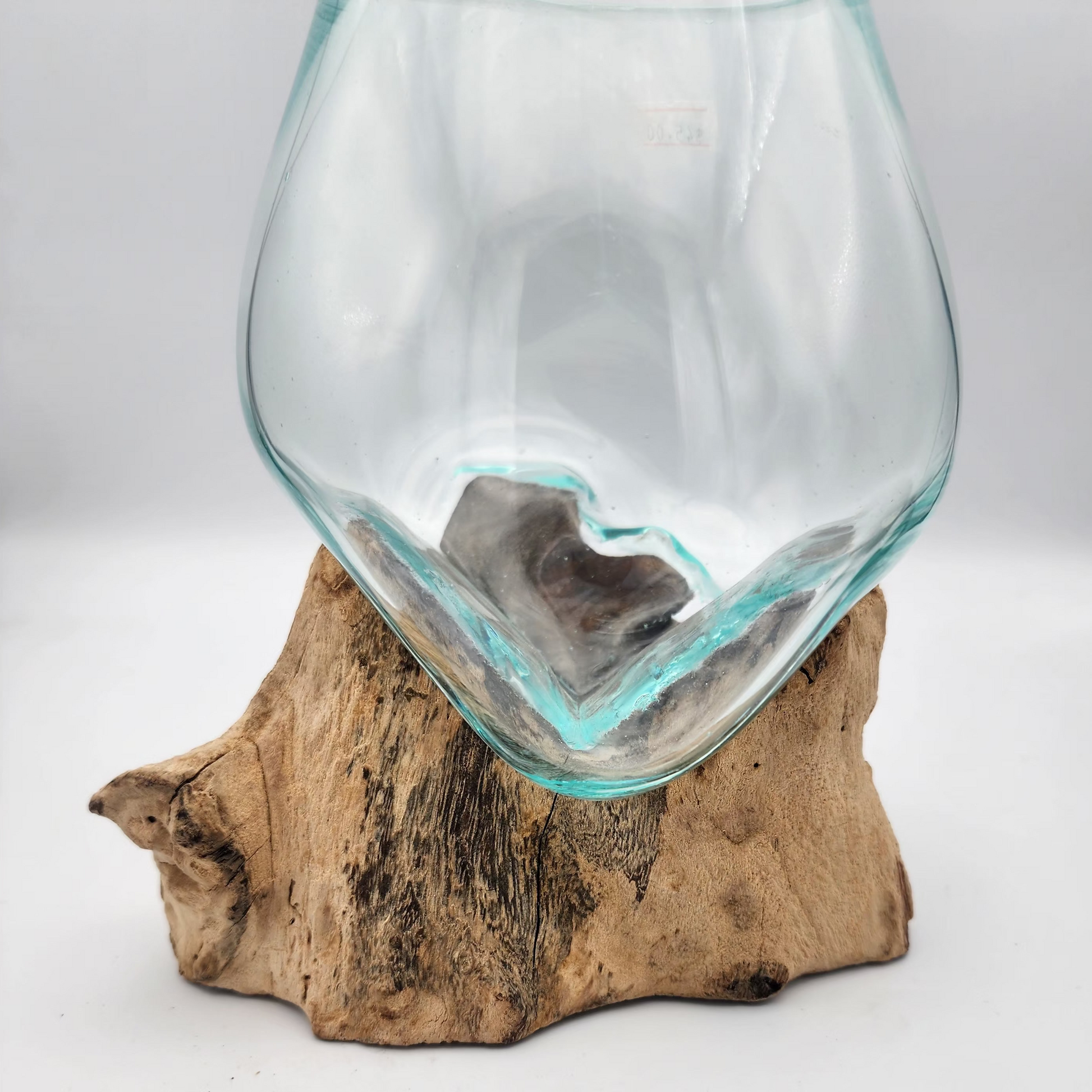 Clear glass vase on a wooden base against a white background