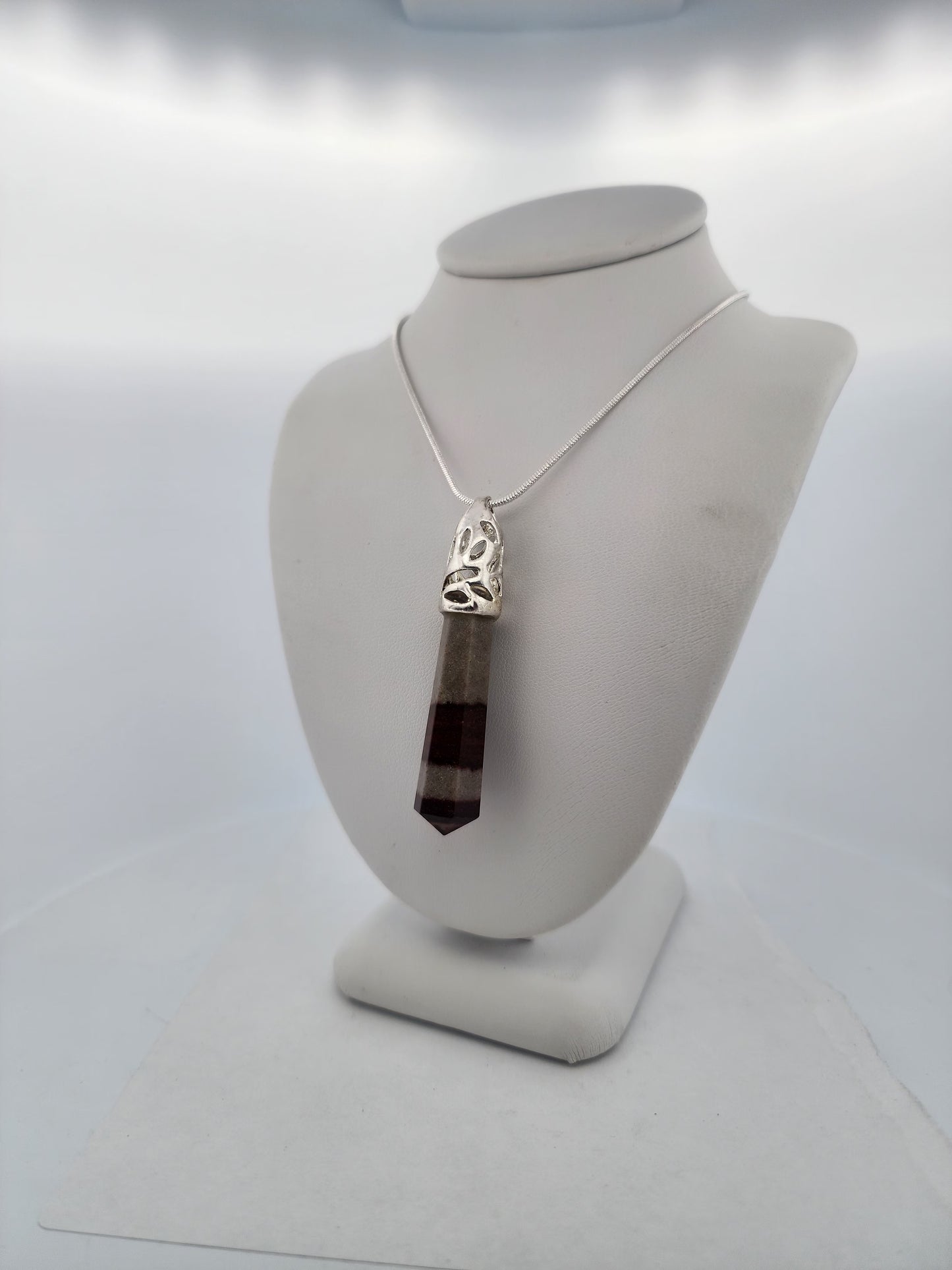 Necklace with a pendant on a mannequin bust against a white background