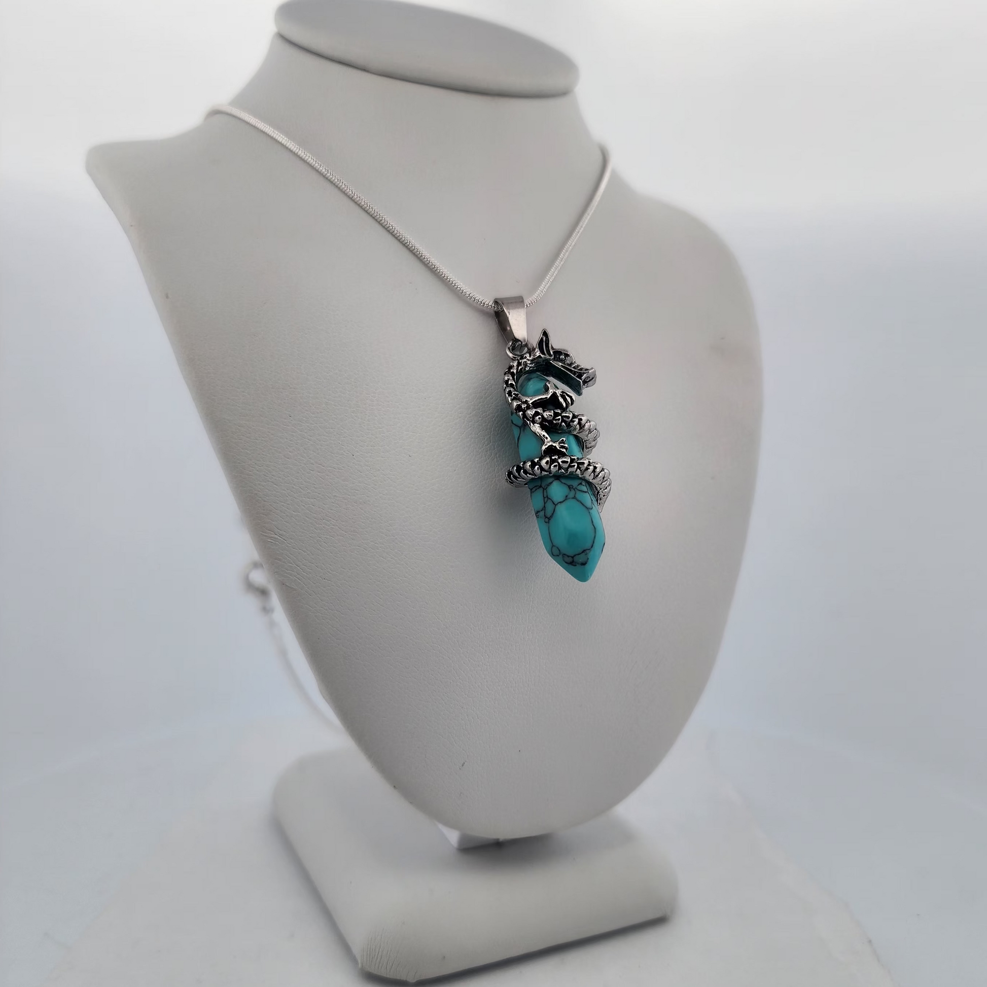 Turquoise necklace on a white bust against a light gray background