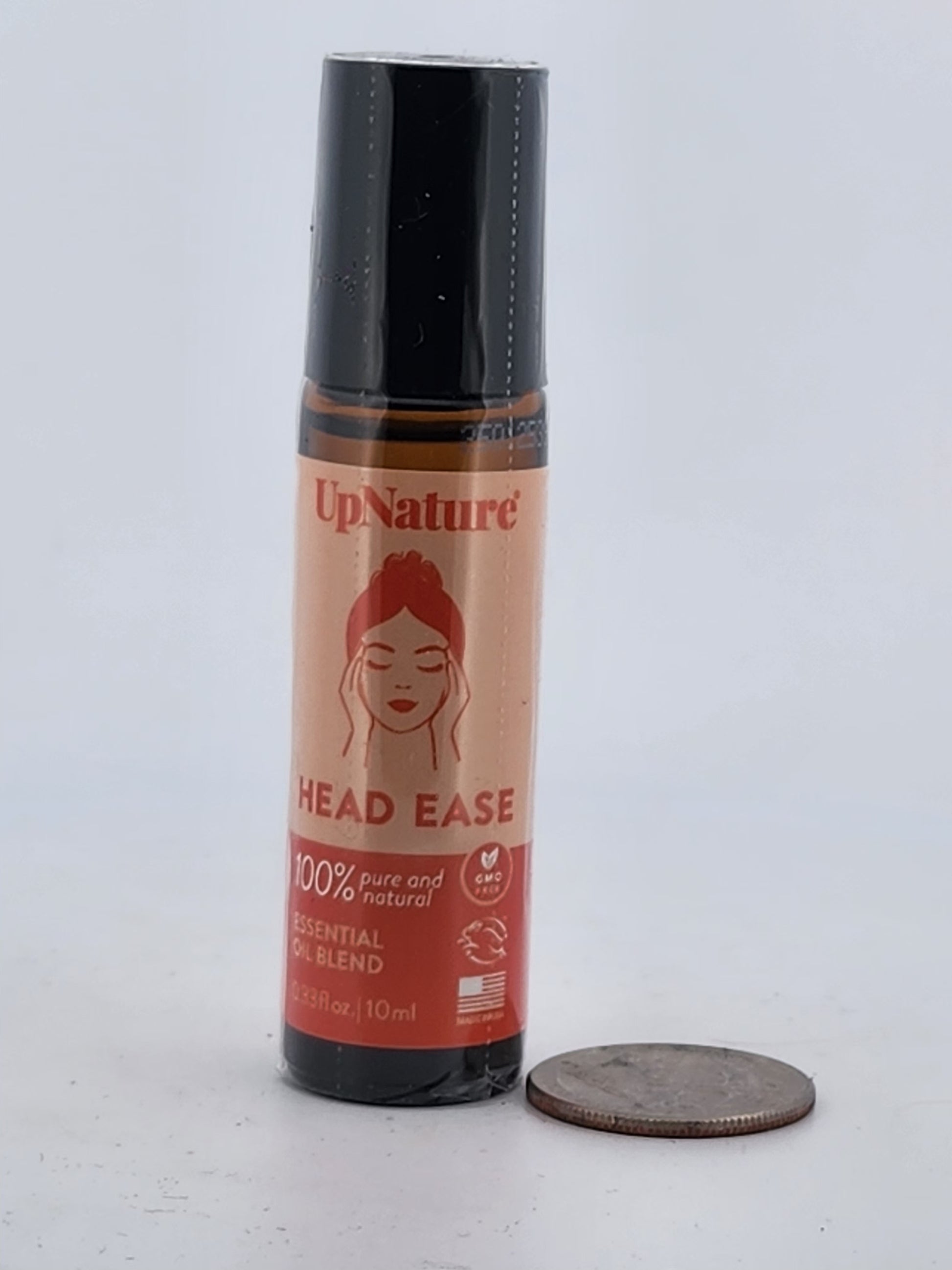 UpNature Head Ease bottle on a white background with a coin for scale