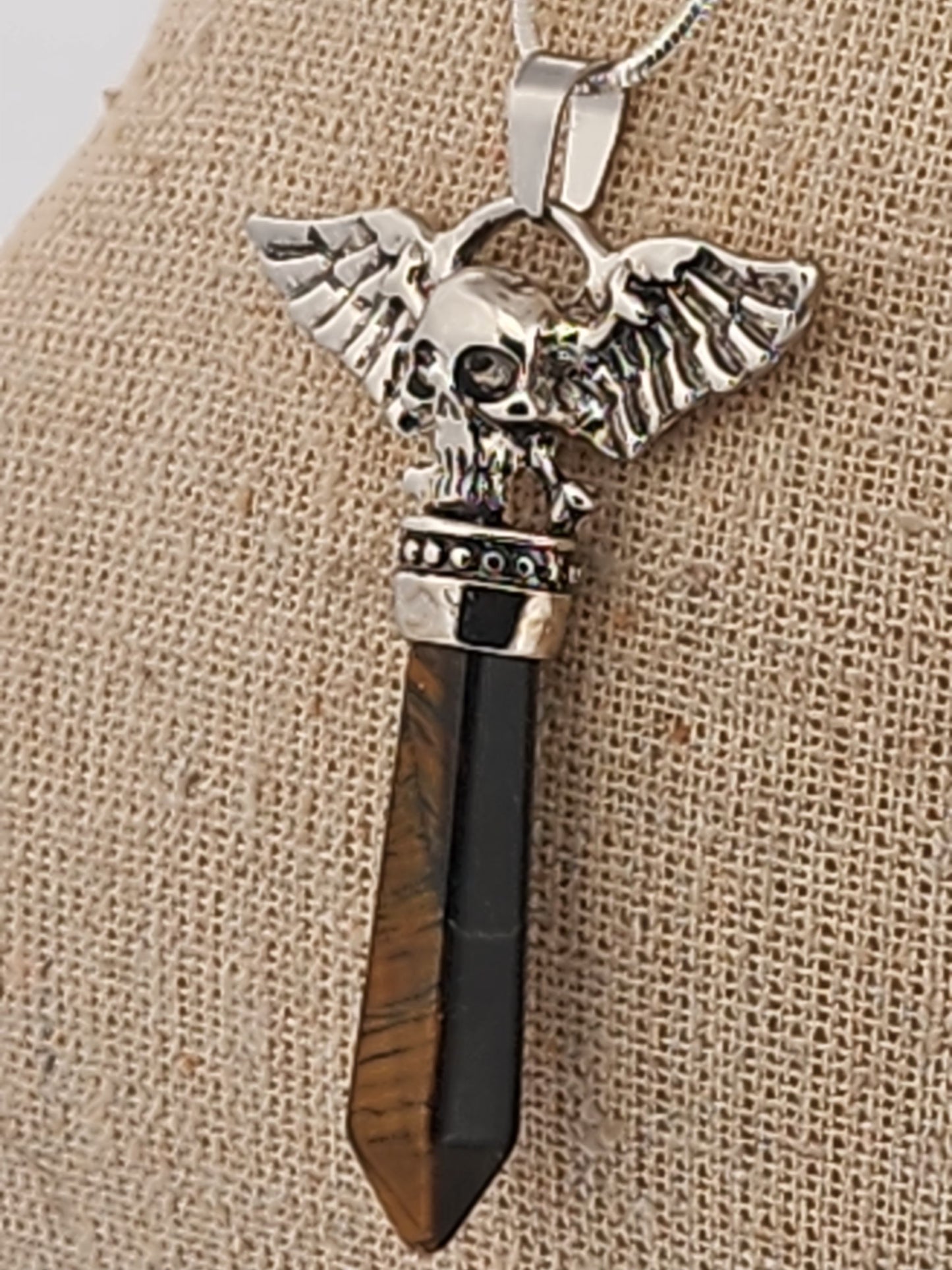 Necklace with an Skull wing pendant on a mannequin bust against a white background