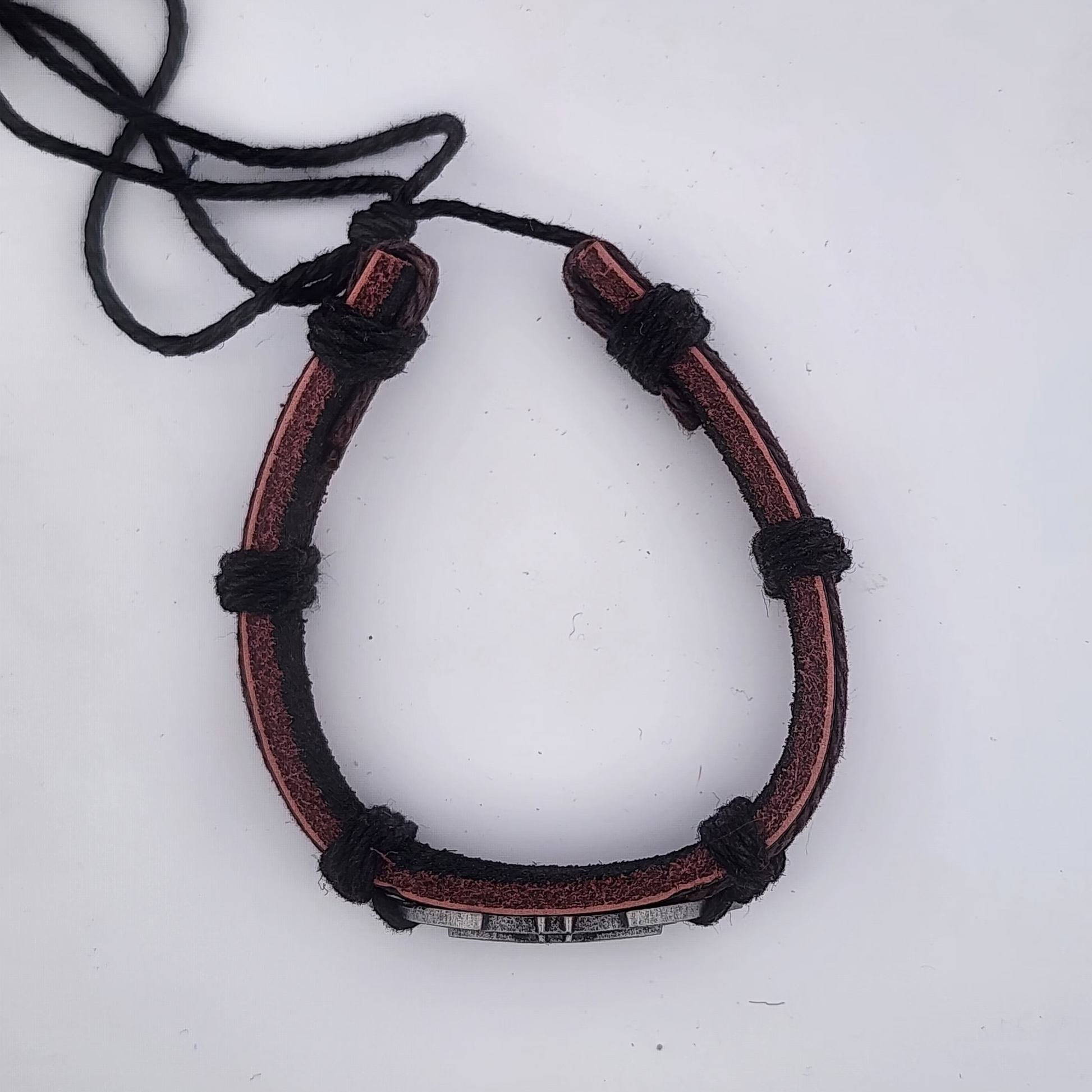 Brown leather bracelet with black cord on a white background