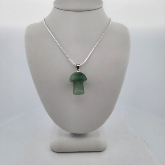 Green pendant necklace on a white bust against a white background