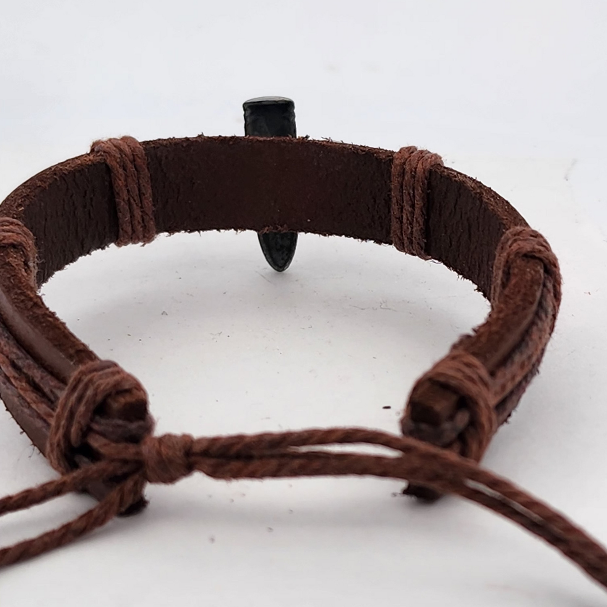 Brown woven bracelet with a black clasp on a white background