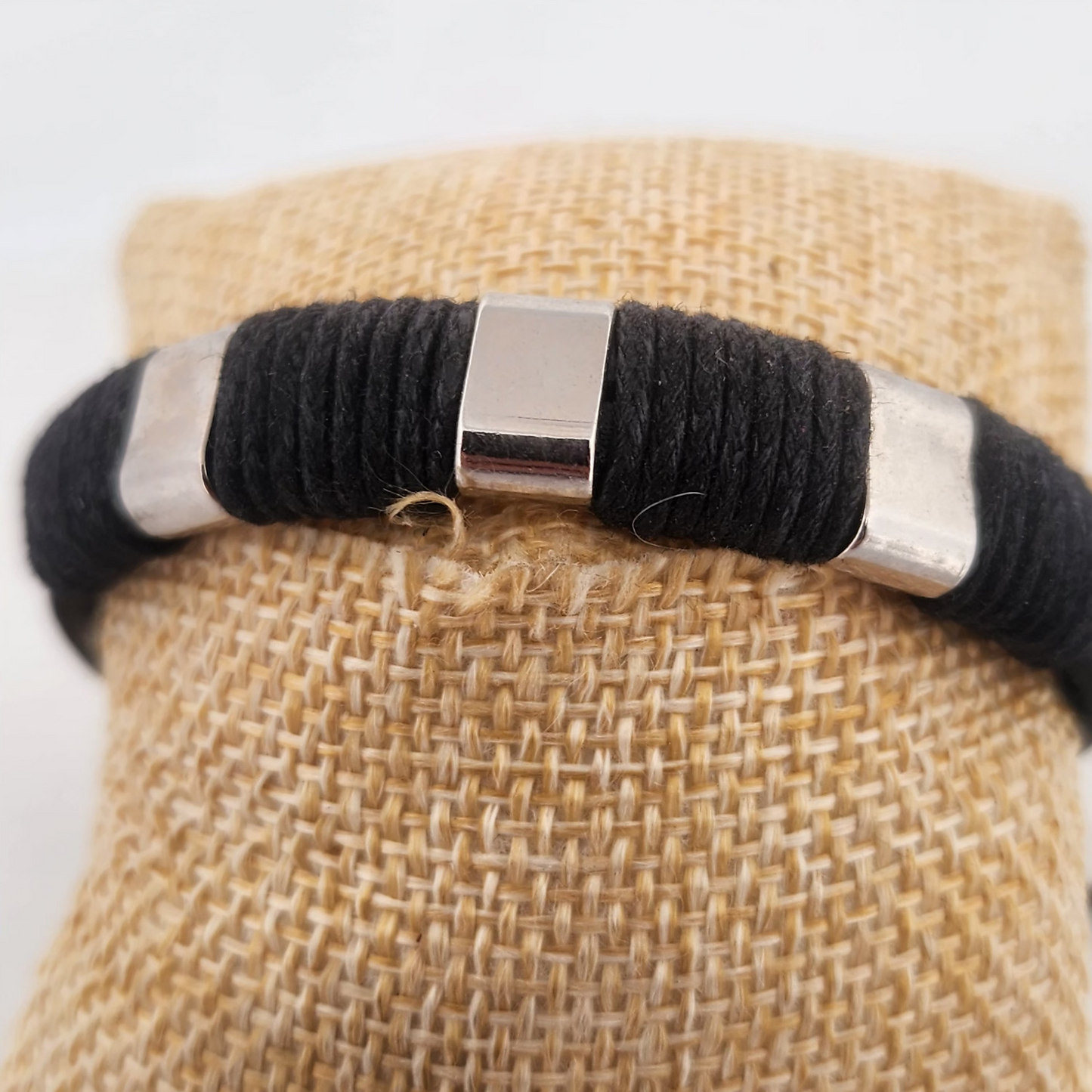 Black and silver bracelet on a burlap surface