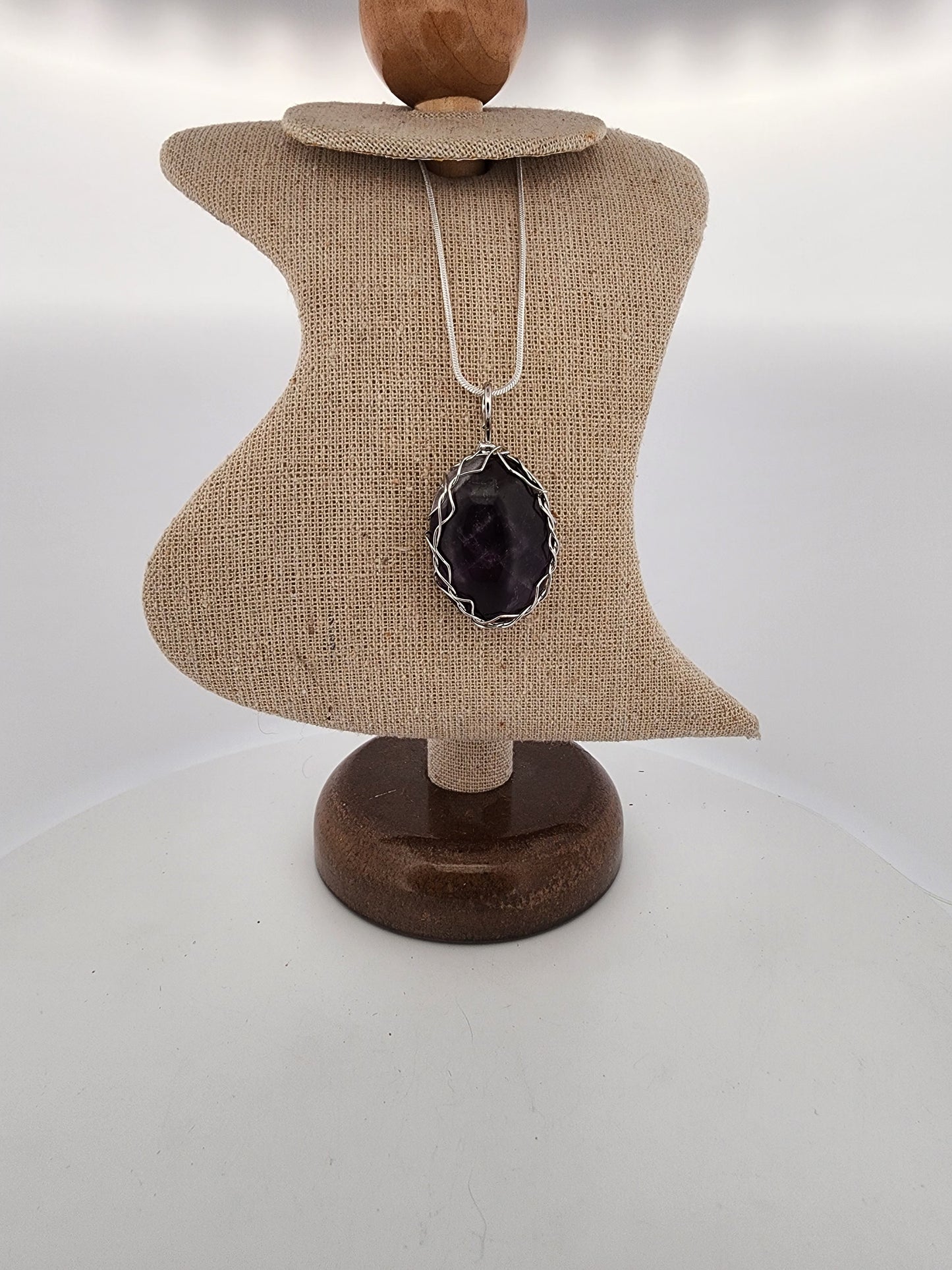 Necklace with a black pendant on a mannequin bust against a white background