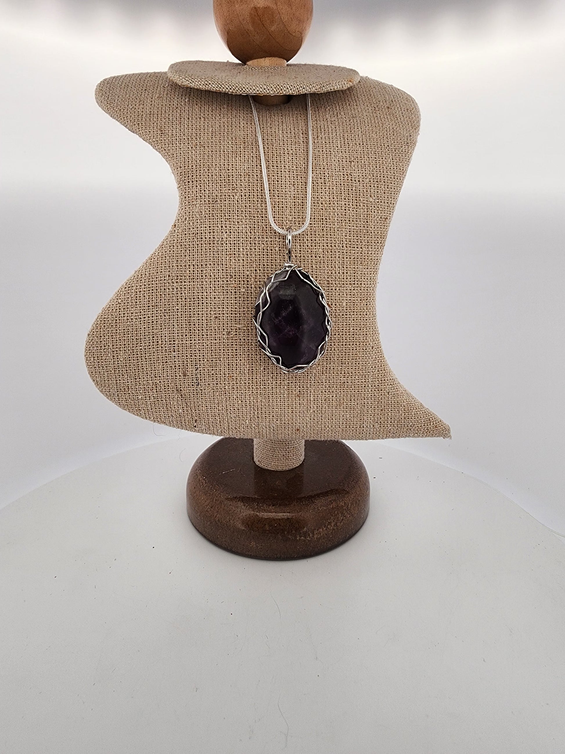 Necklace with a black pendant on a mannequin bust against a white background