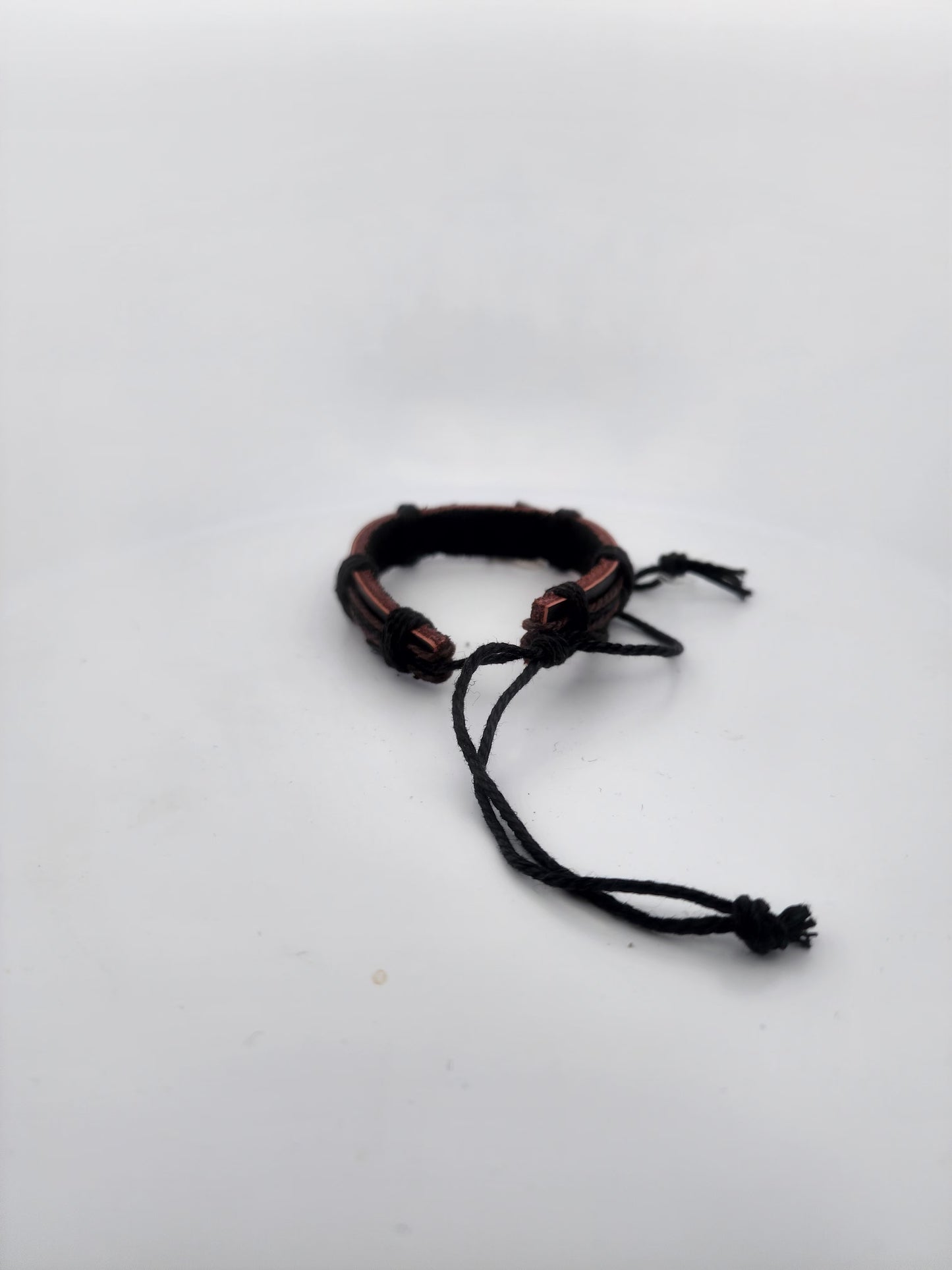 Bracelet with brown and black cord on a white background