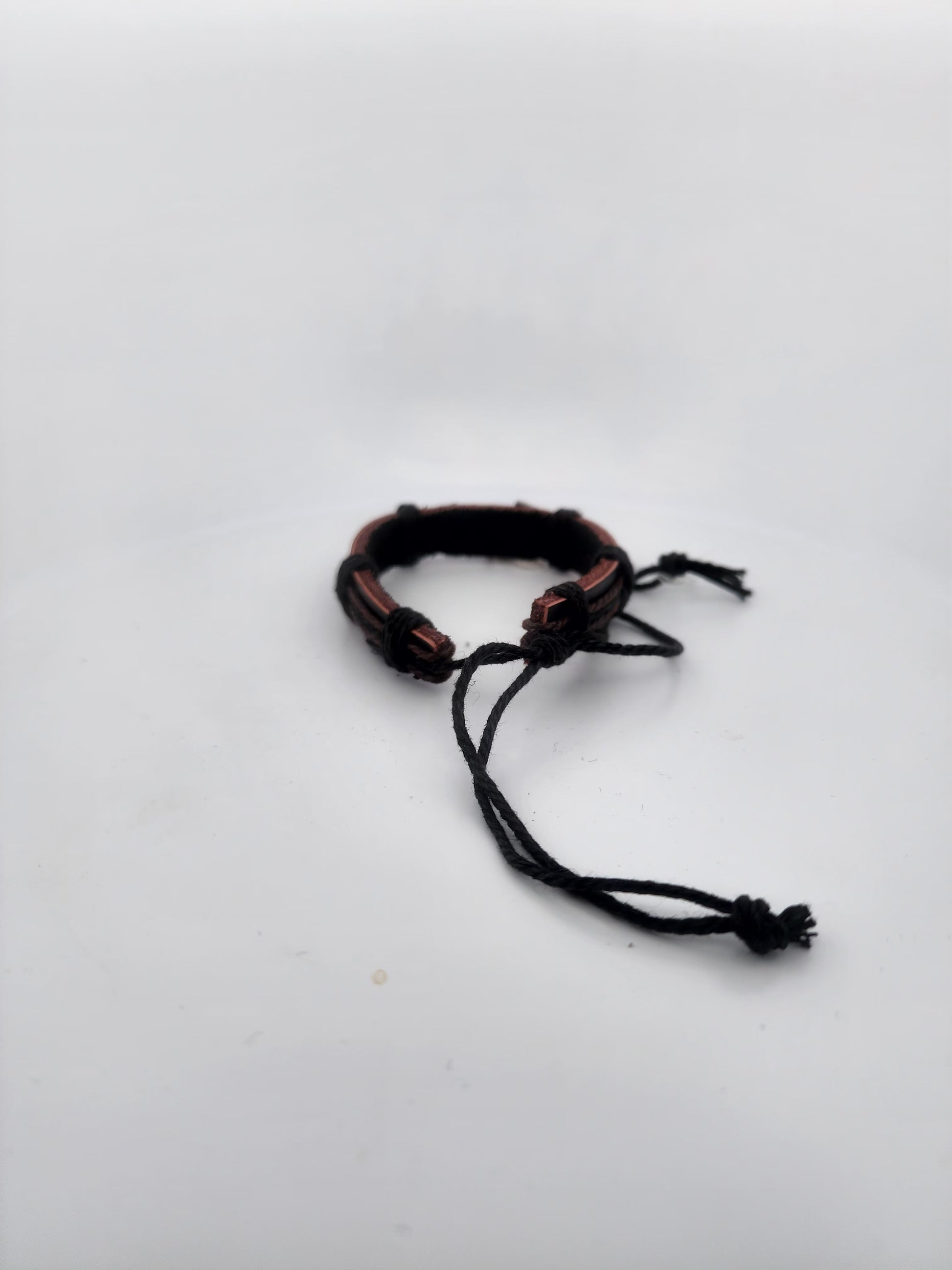 Bracelet with brown and black cord on a white background