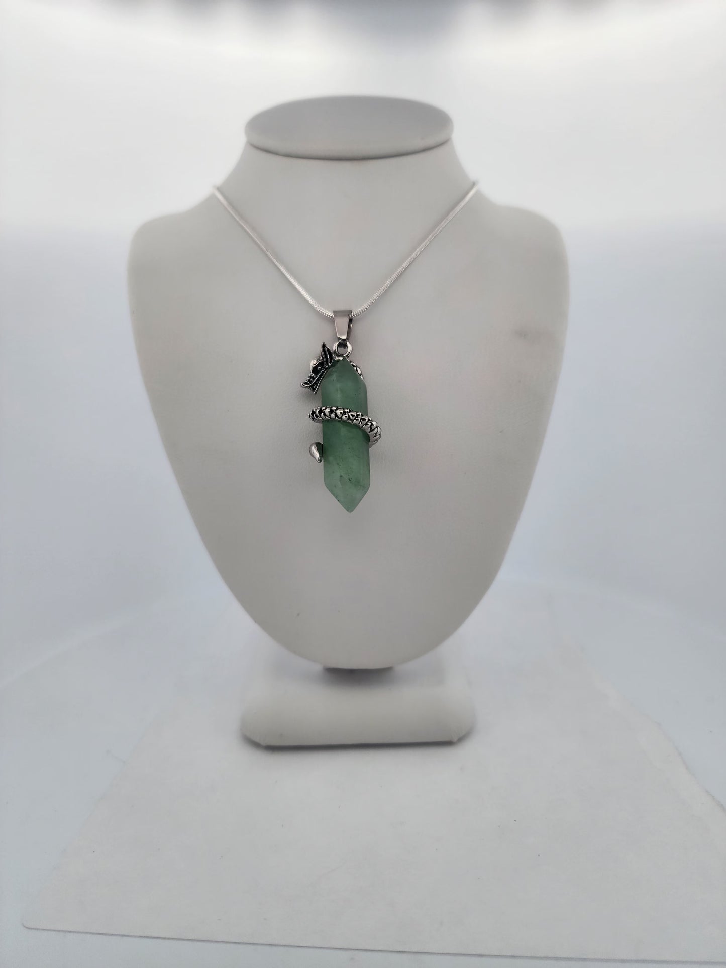 Necklace with a green pendant on a mannequin bust against a white background