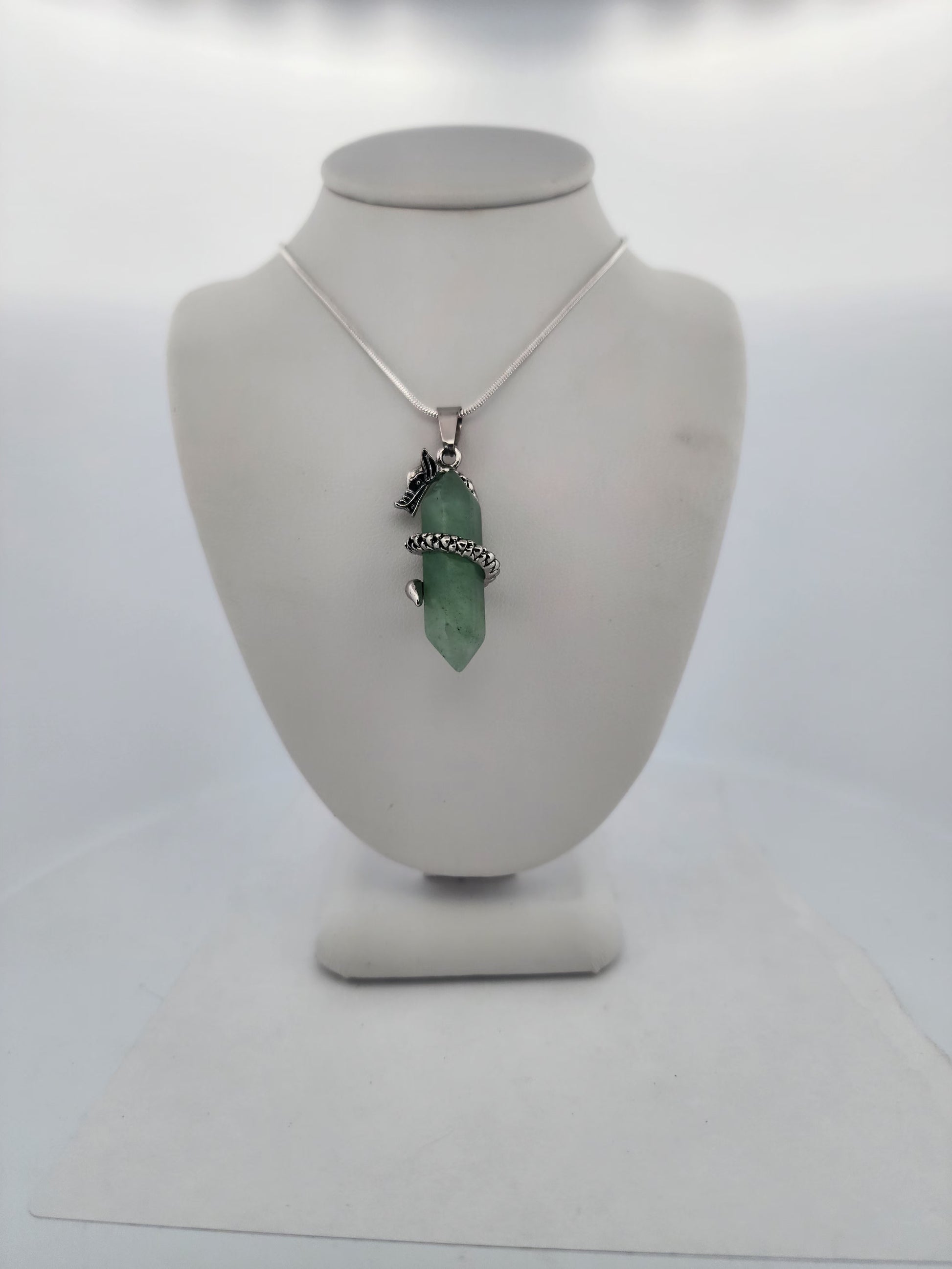 Necklace with a green pendant on a mannequin bust against a white background