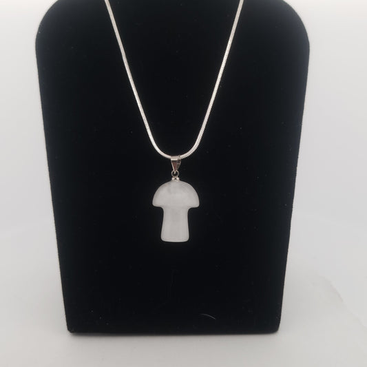 White pendant necklace on a black stand against a white background
