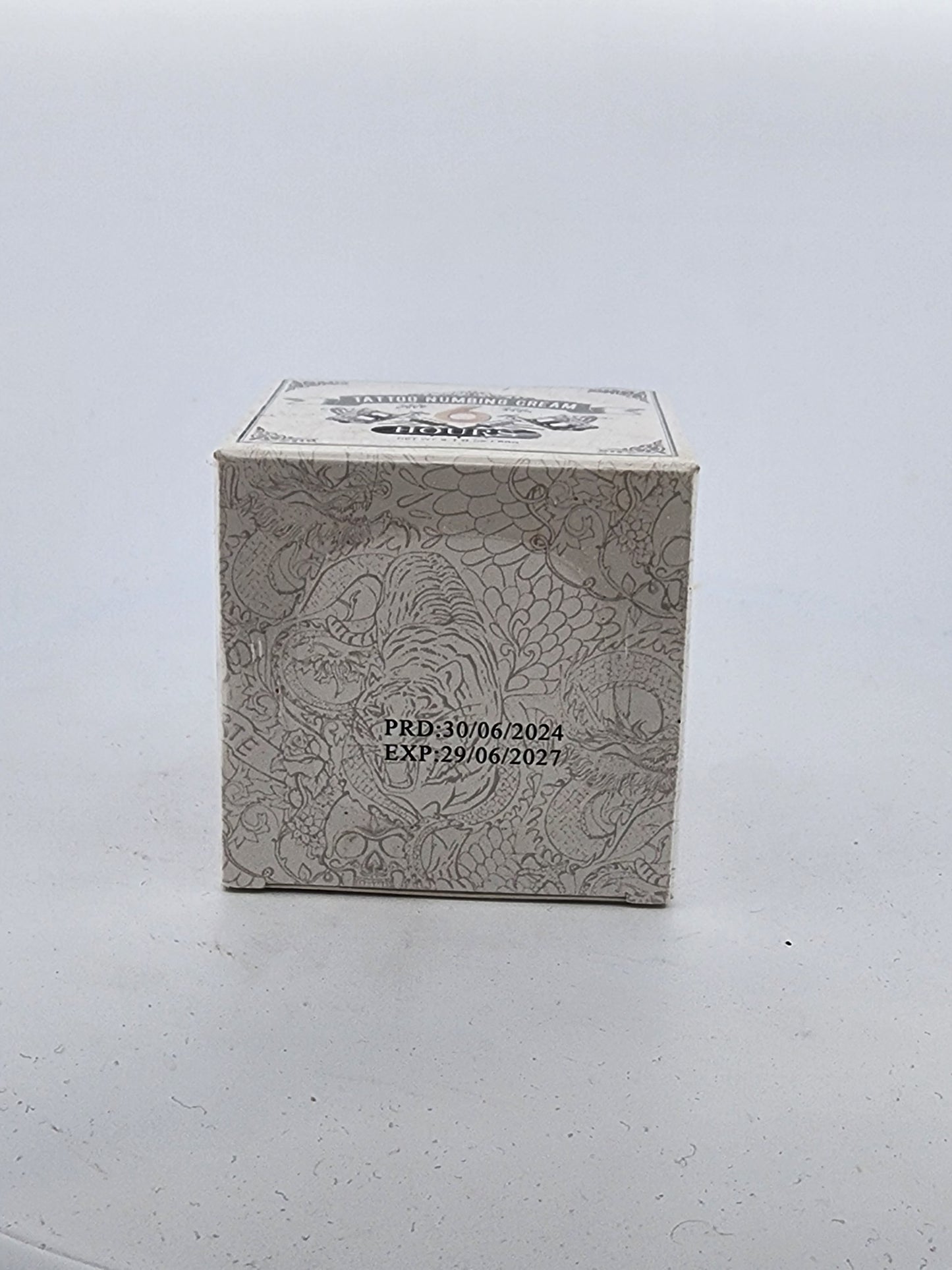 Small rectangular box with textured surface and printed text on a light gray background