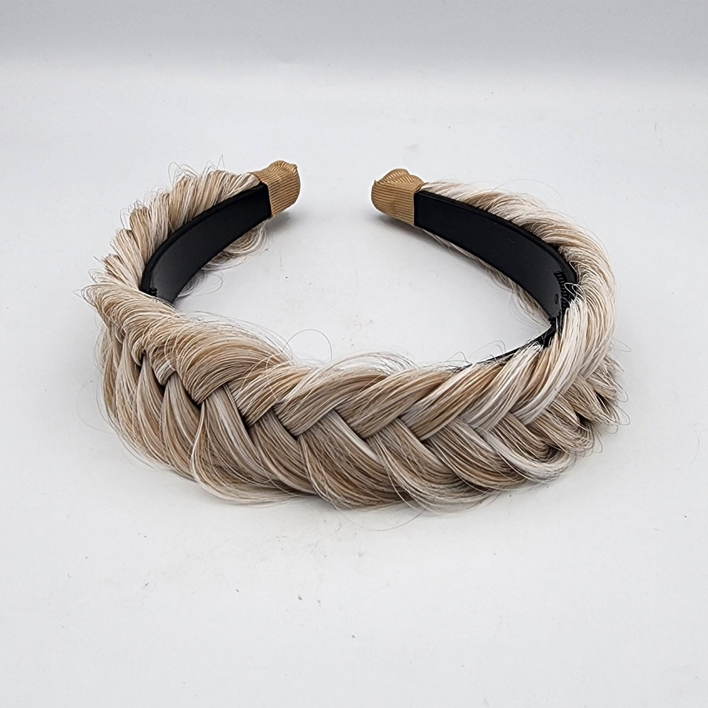 Braided hairband with beige and black straps on a white background