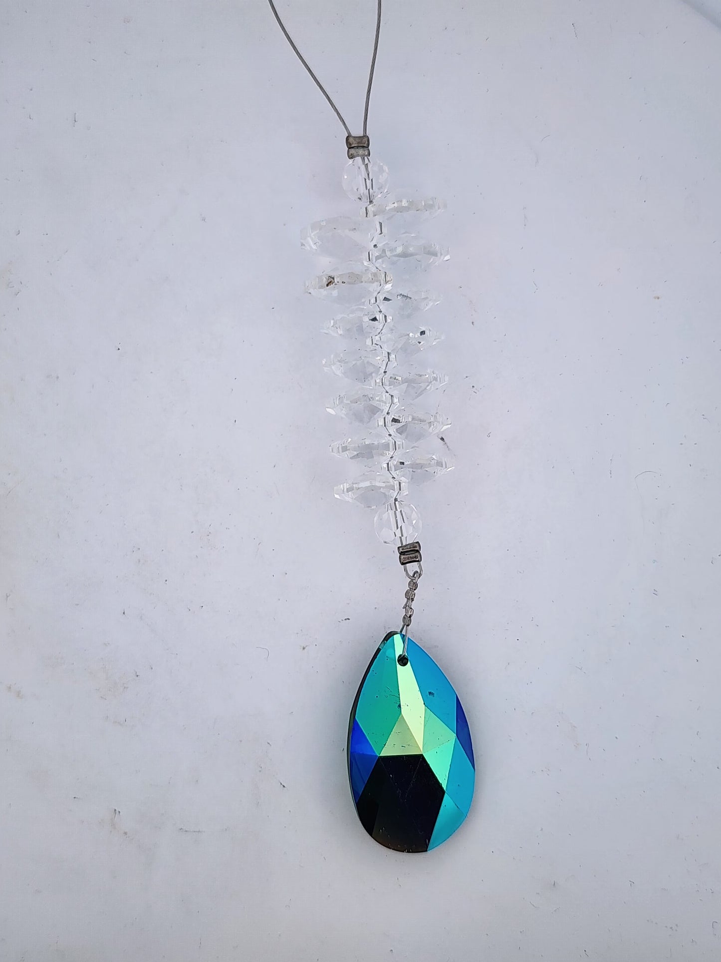 Teardrop-shaped pendant with multicolored design on a white background