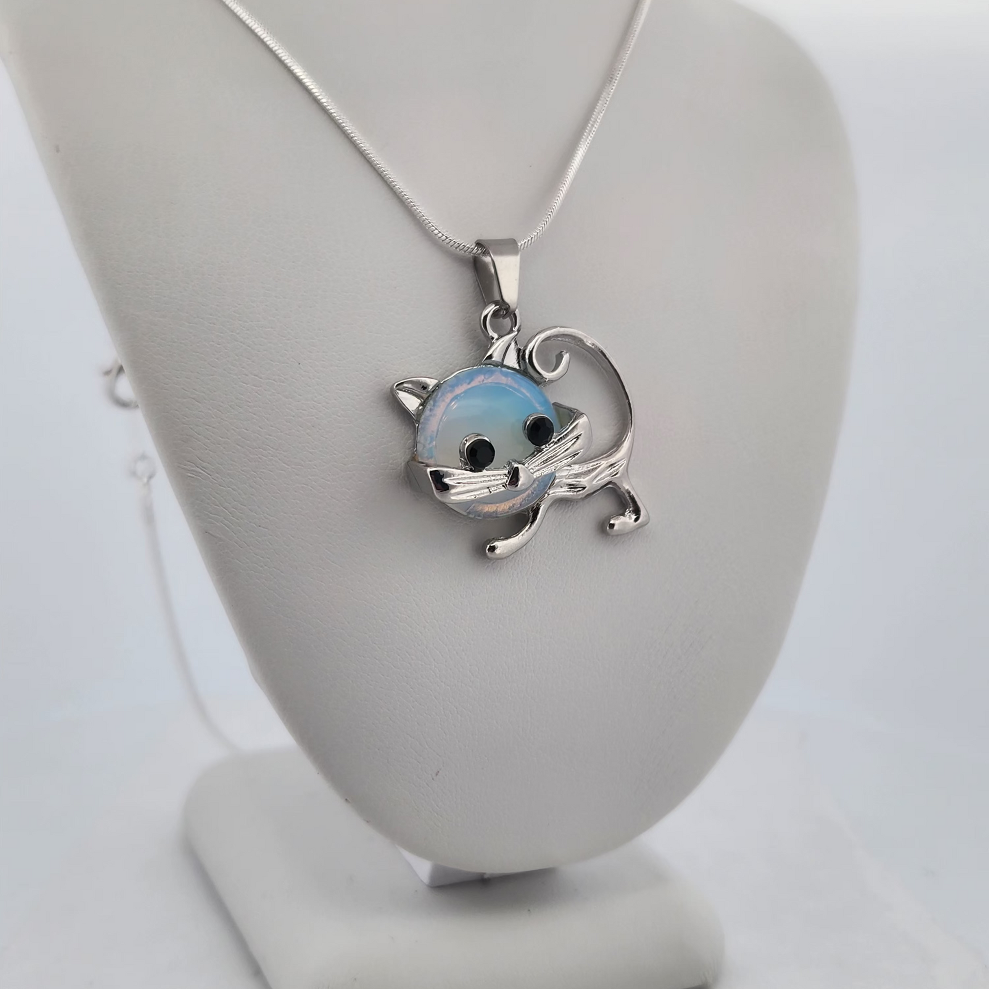 Silver pendant on a mannequin bust with a white background