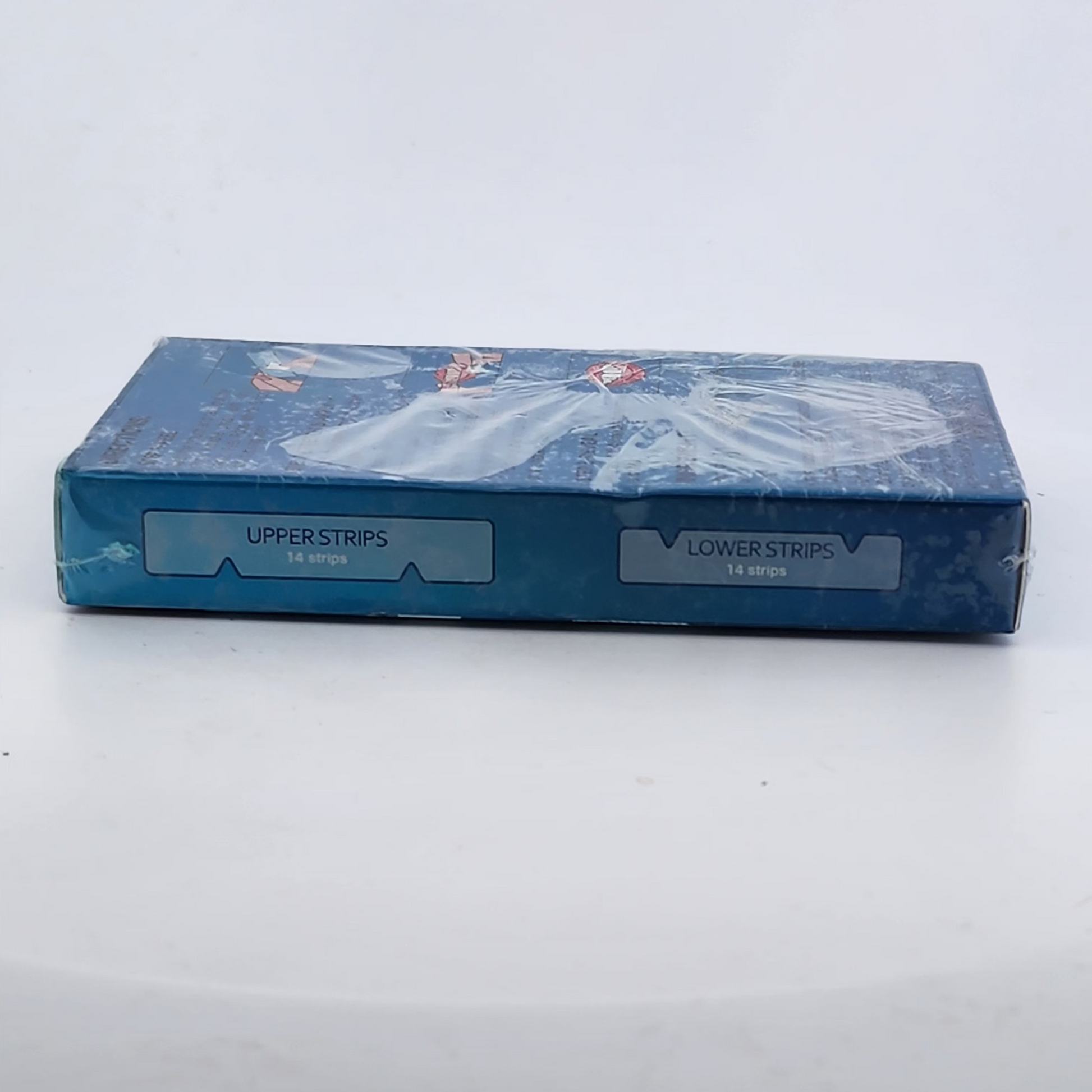 Blue box of dental strips on a white surface with a light gray background