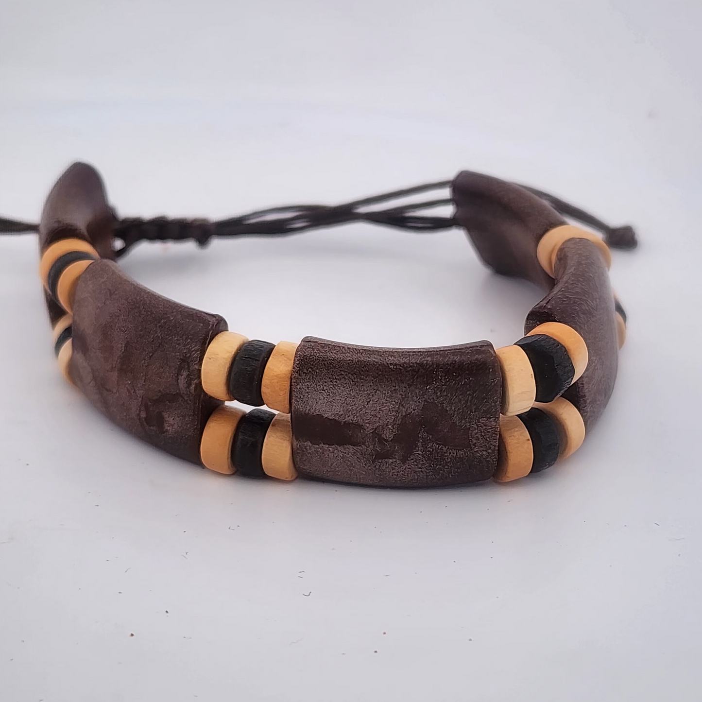 Bracelet with brown leather and wooden beads on a white background