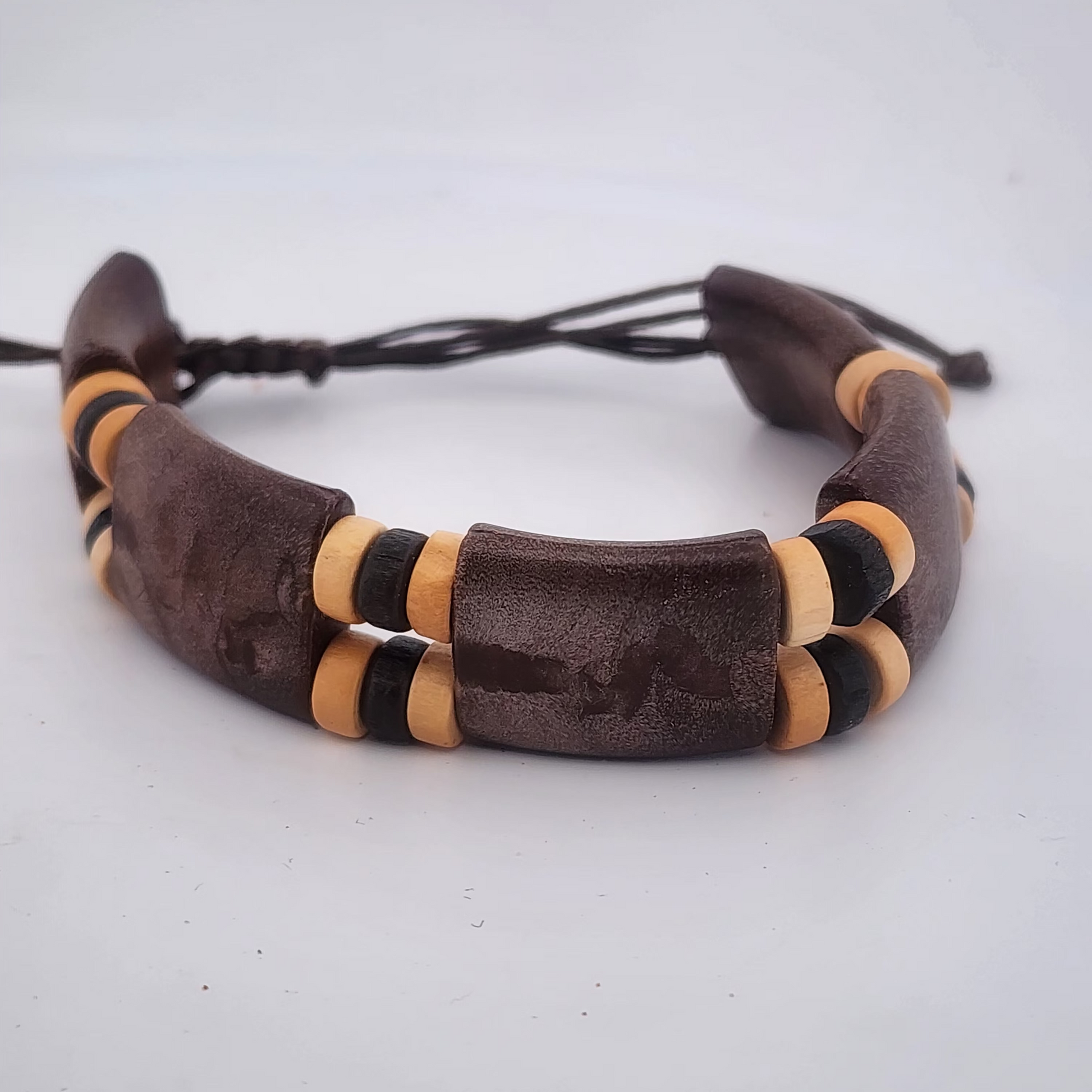 Bracelet with brown leather and wooden beads on a white background