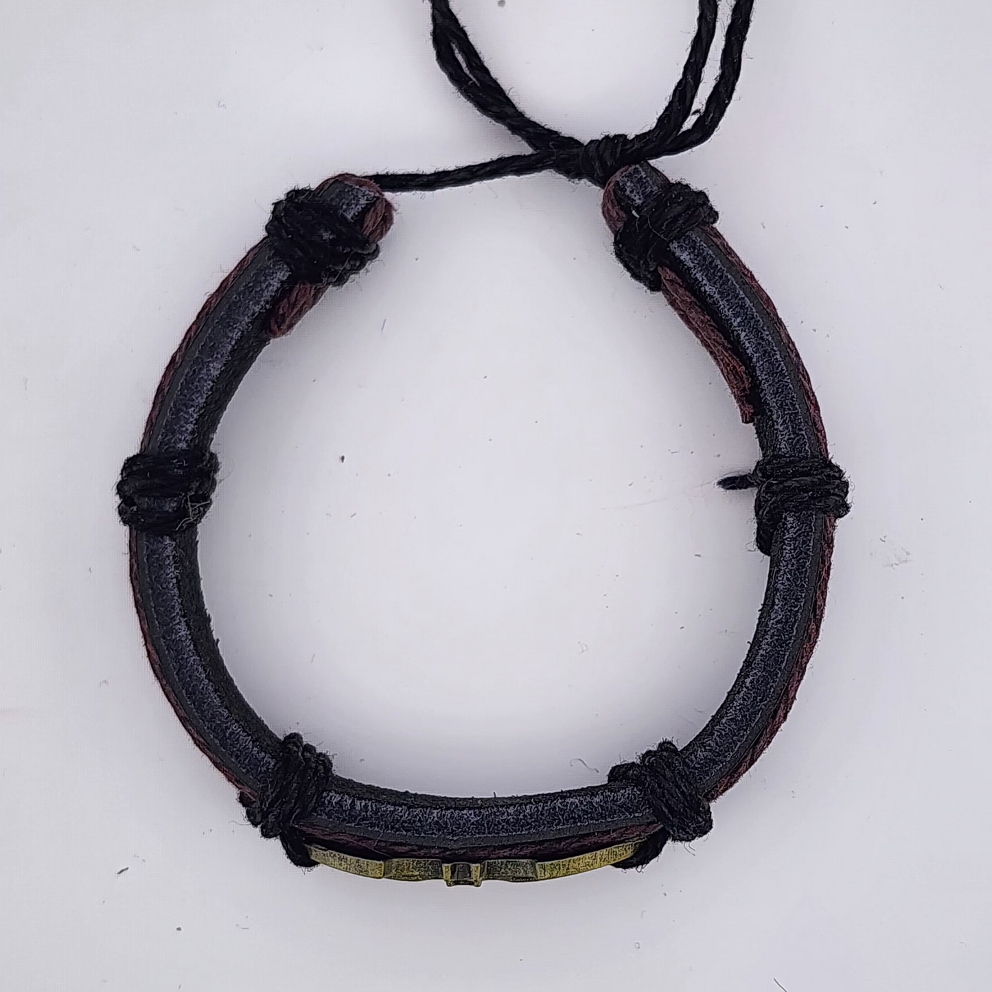 Bracelet with black cord and metal clasp on a white background
