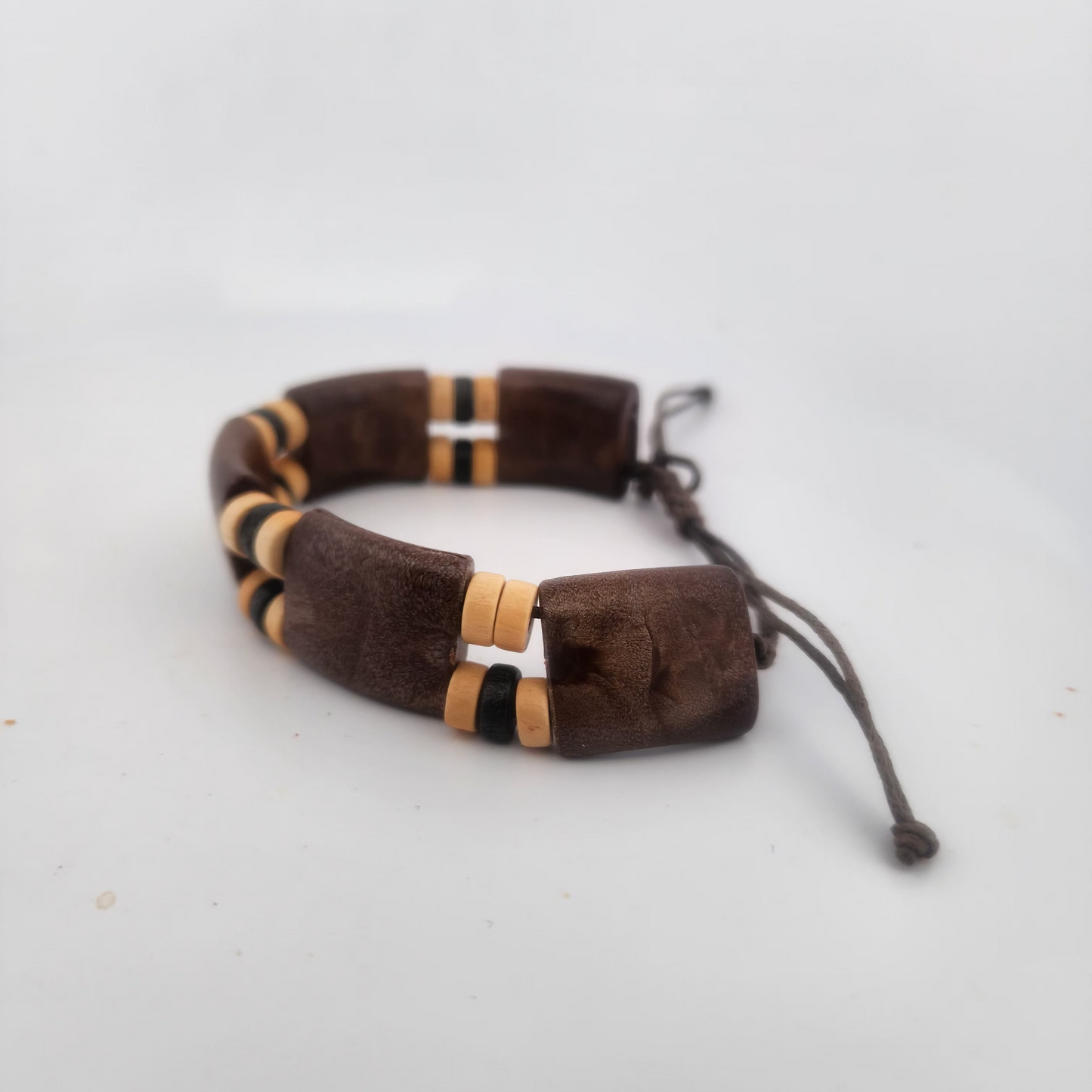 Brown leather bracelet with gold and black accents on a white background
