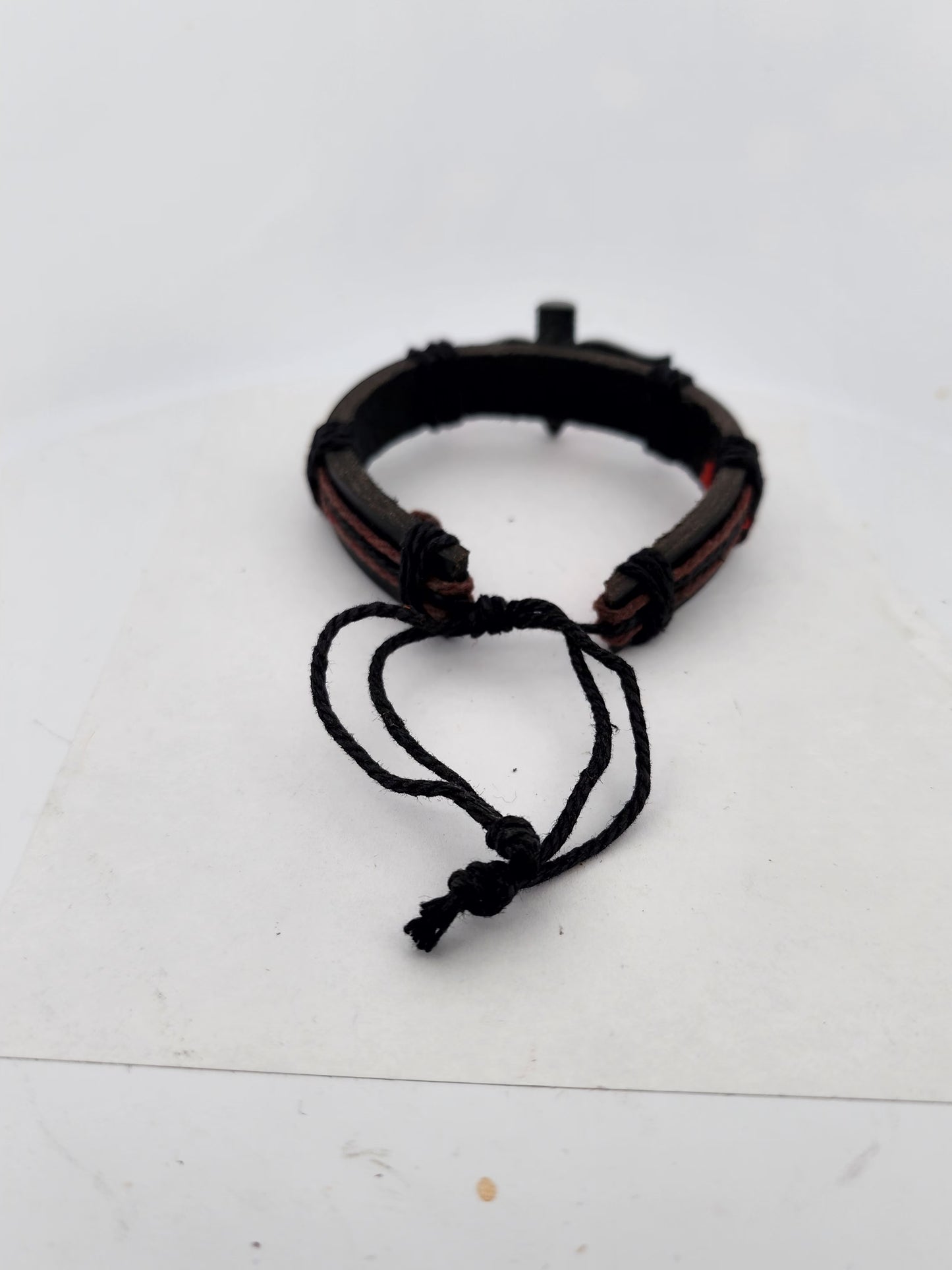 Brown leather bracelet with black cord on a white background