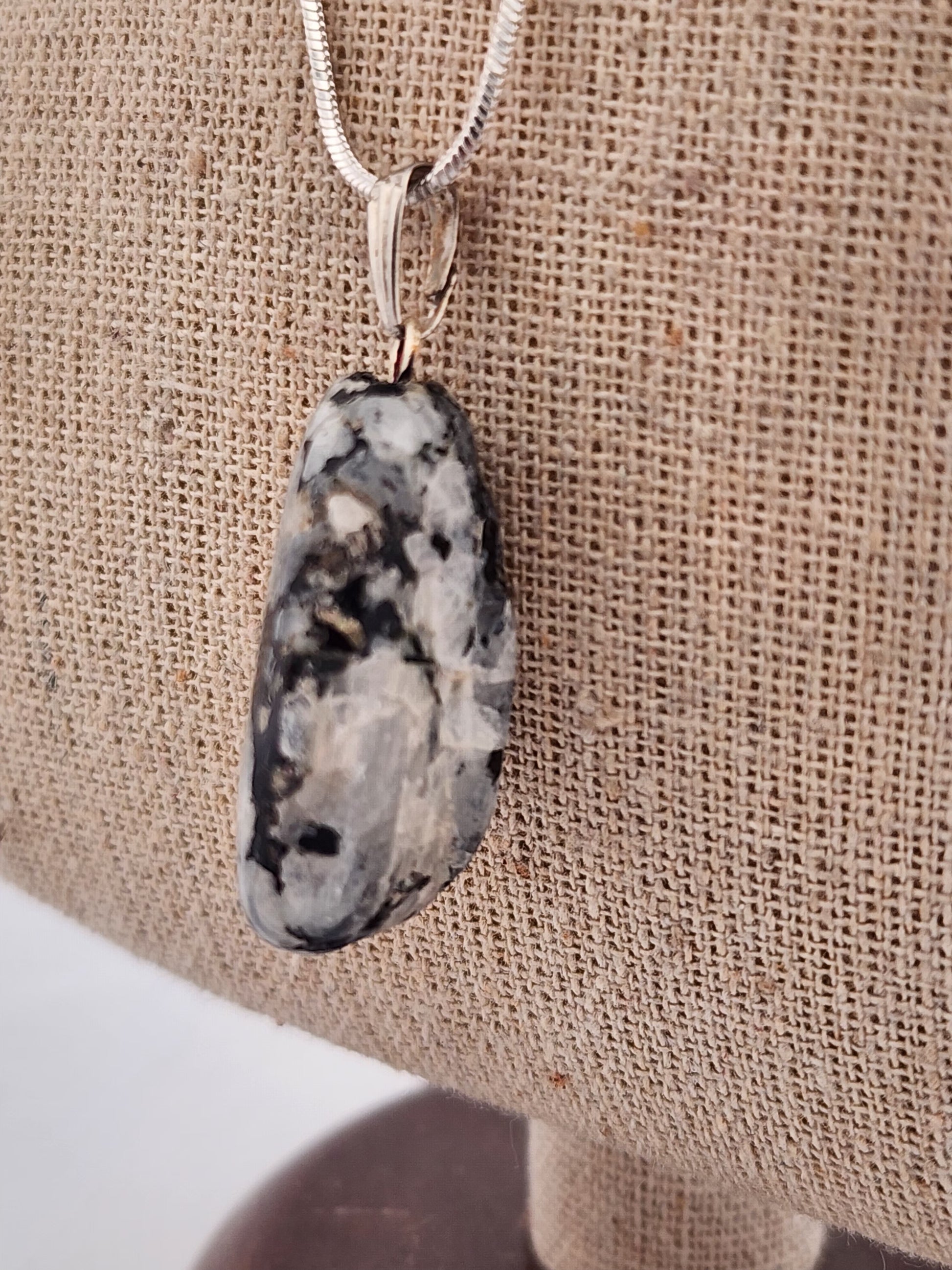 Necklace with a pendant on a beige fabric background