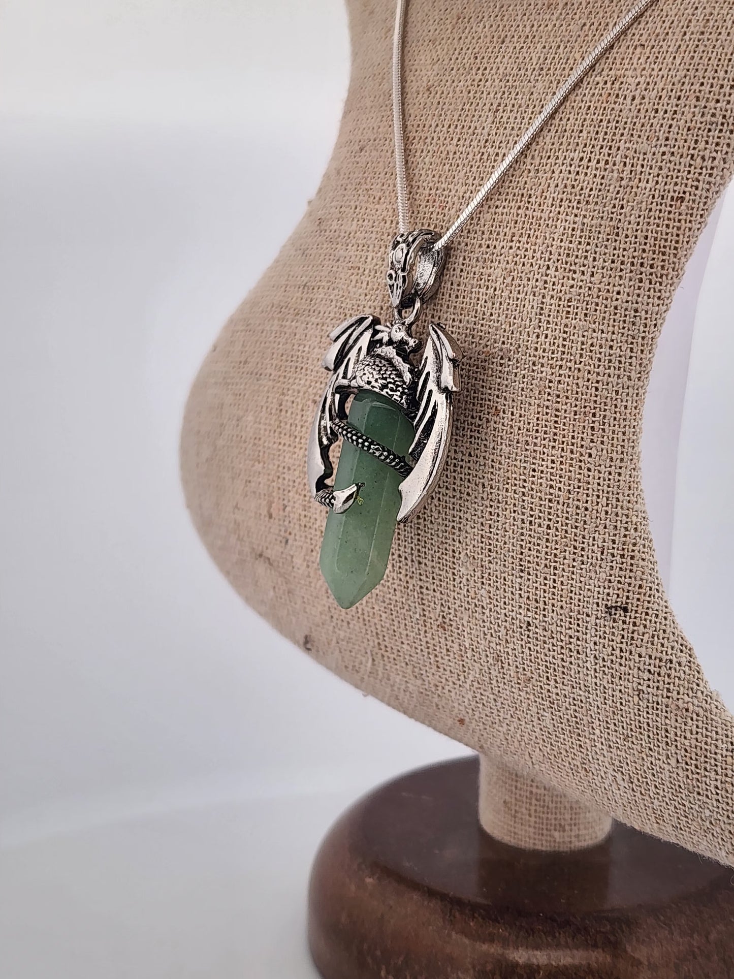 Necklace with a green pendant on a mannequin bust against a white background