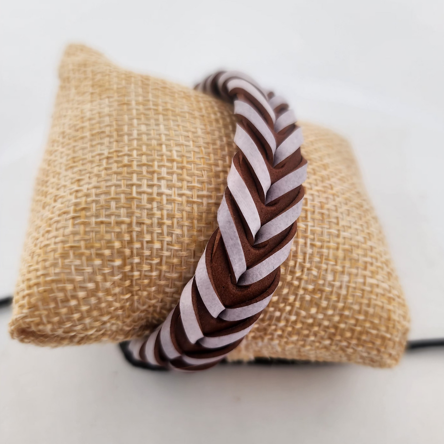 Brown and white striped dog toy on a burlap bag with a white background