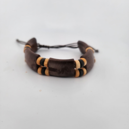 Bracelet with brown and gold cylindrical beads on a white background
