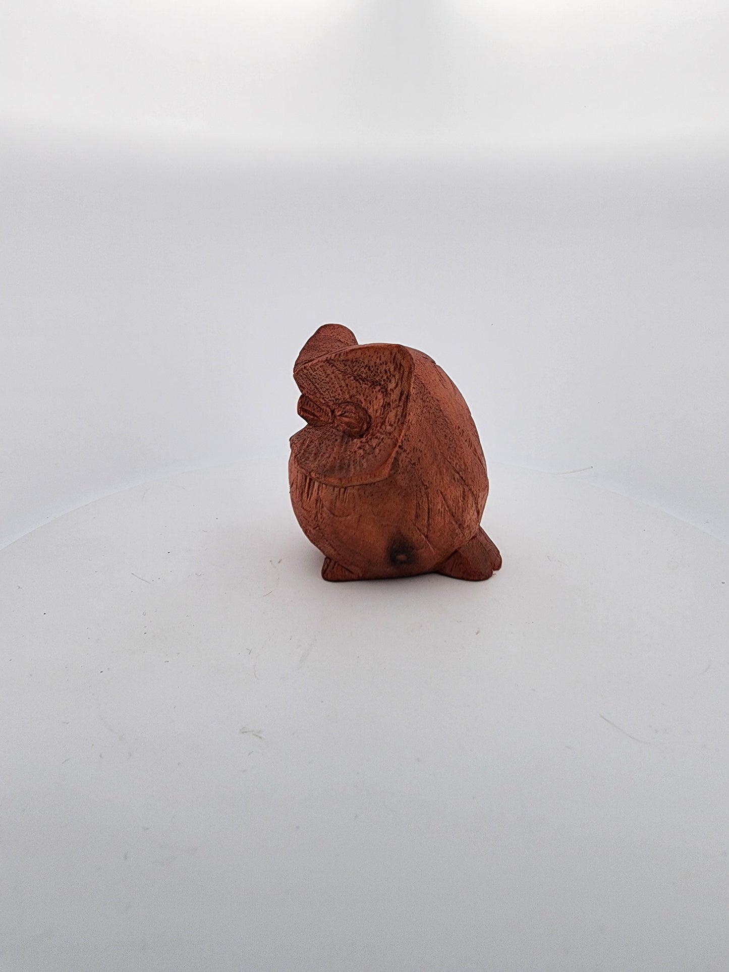 Small terracotta chicken figurine on a white background