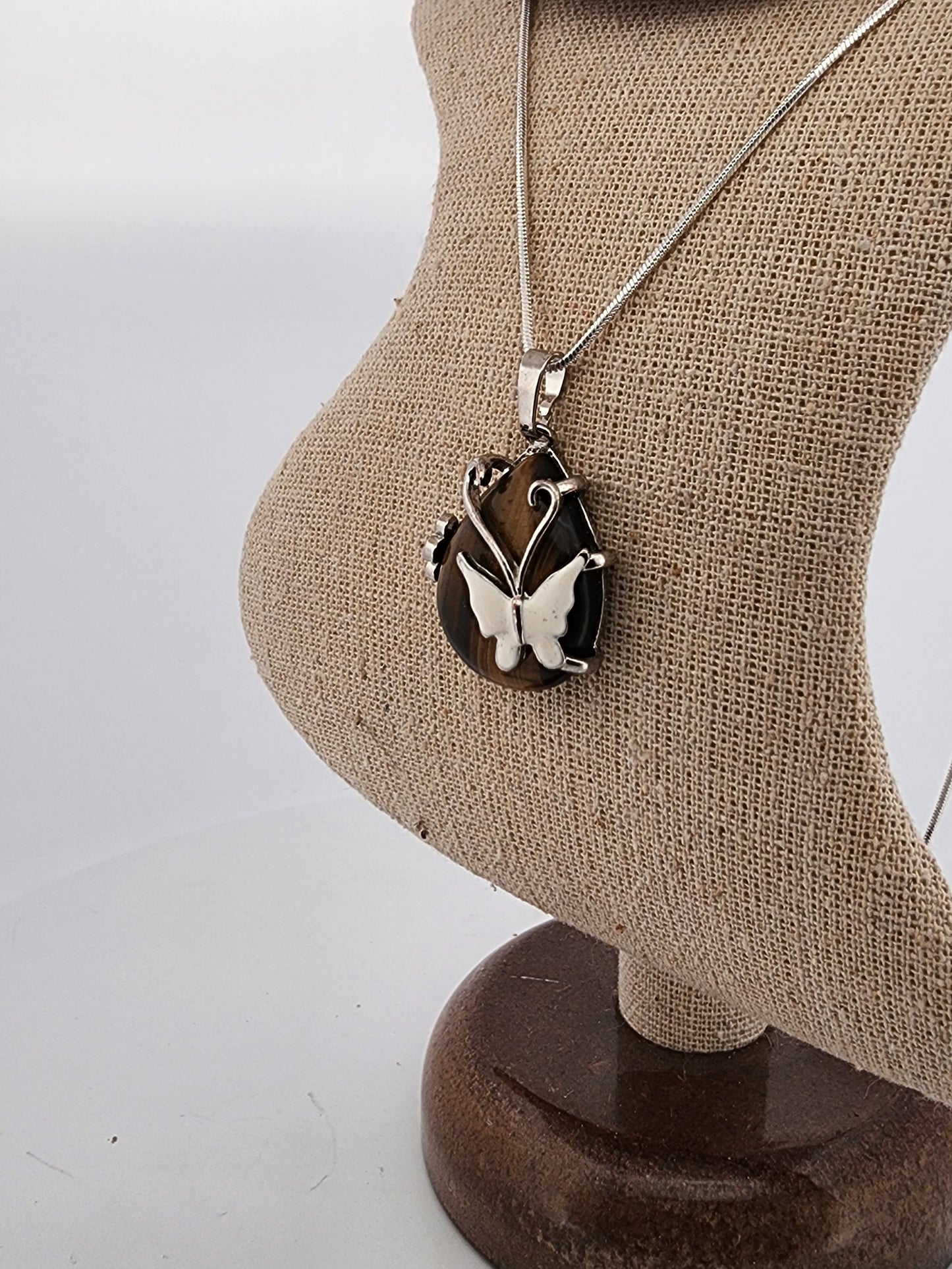 Necklace with a pendant on a burlap-covered mannequin bust.