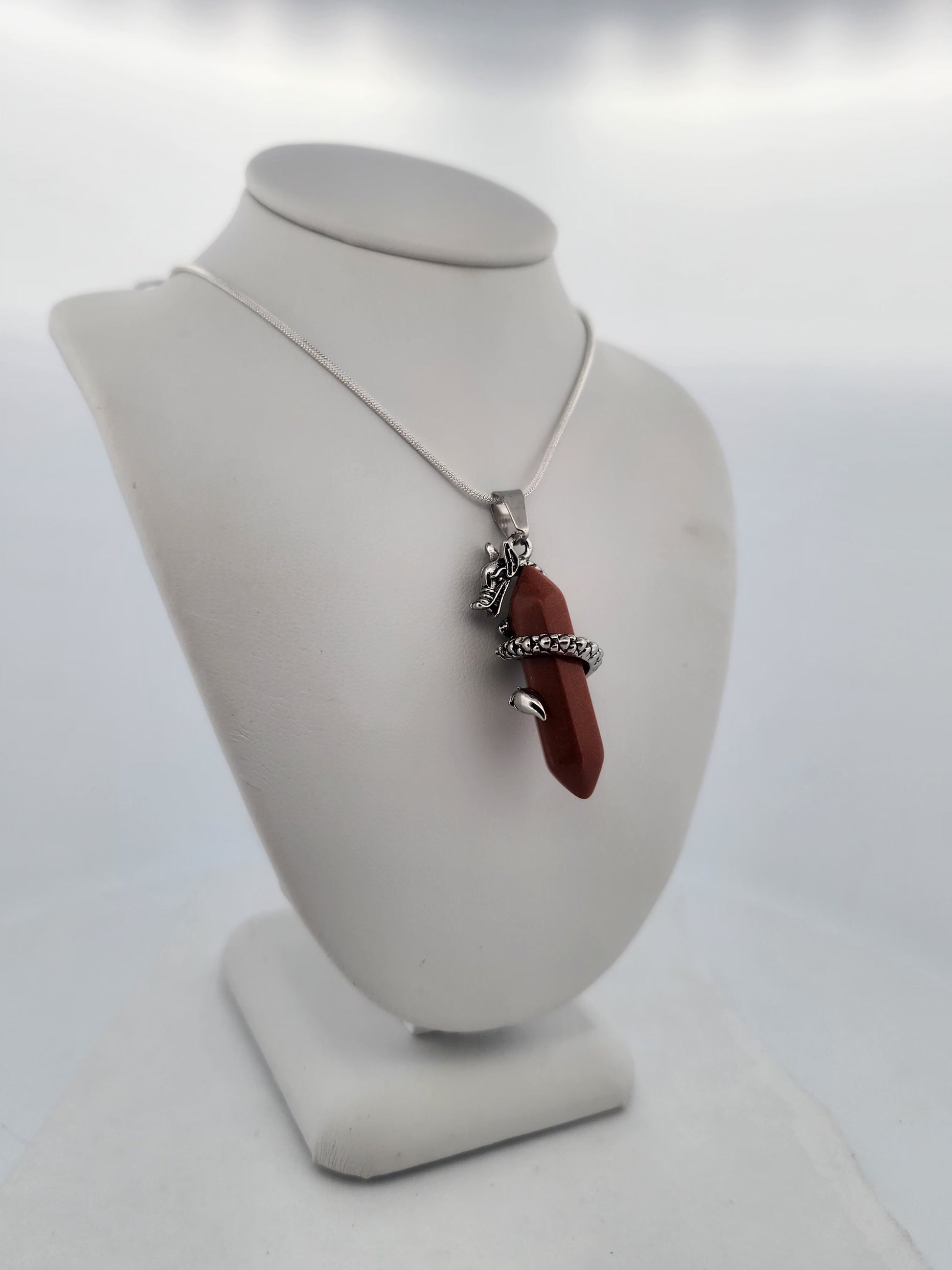 Necklace with a red pendant on a white mannequin bust against a white background