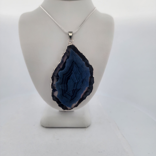 Blue geode pendant on a mannequin bust against a white background